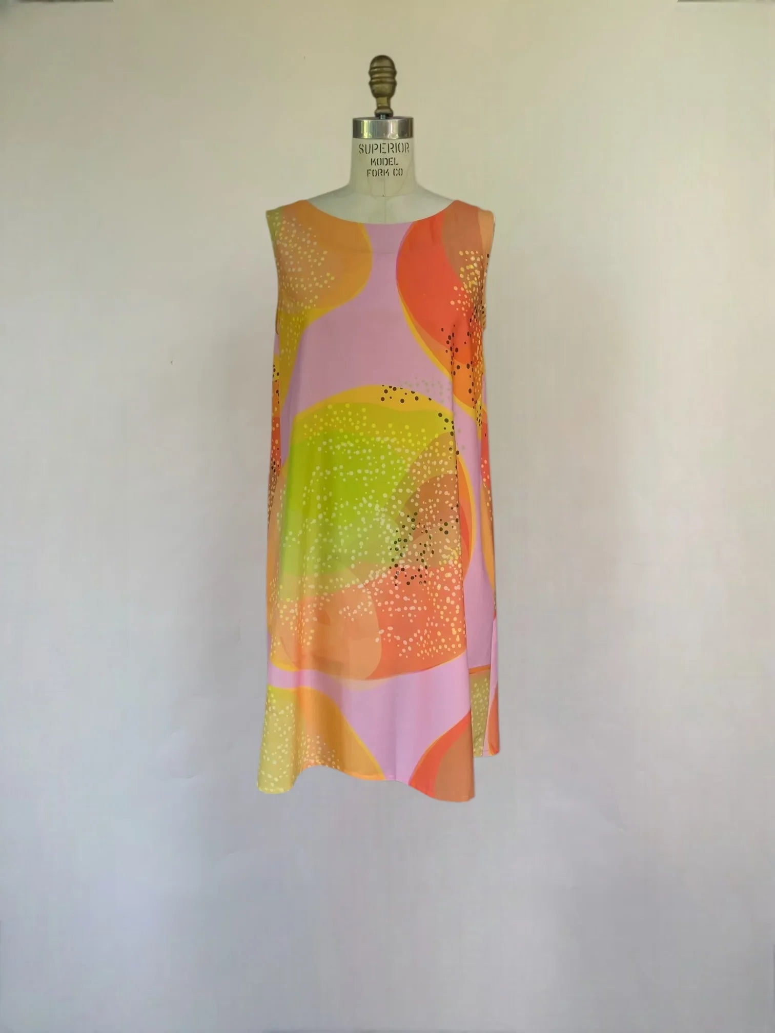 Sleeveless mu'umu'u dress with abstract pastel Hawaiian print on mannequin