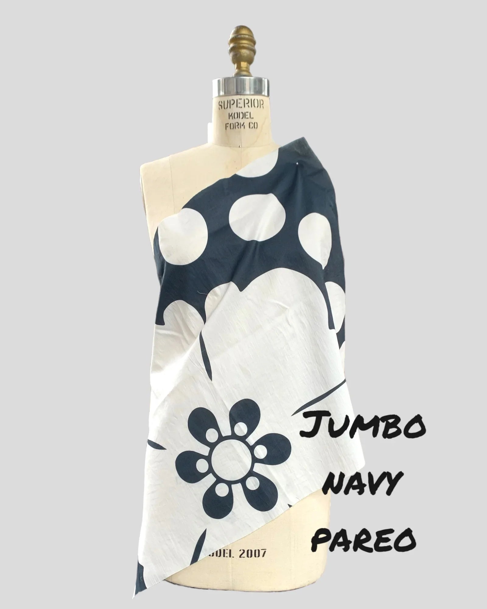 Navy and white Hawaiian pareo with bold floral print draped on dress form