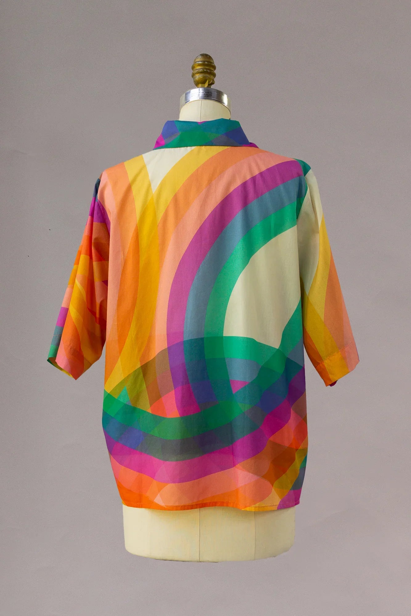 Back view of a short sleeve aloha shirt with bold rainbow print and vibrant colors