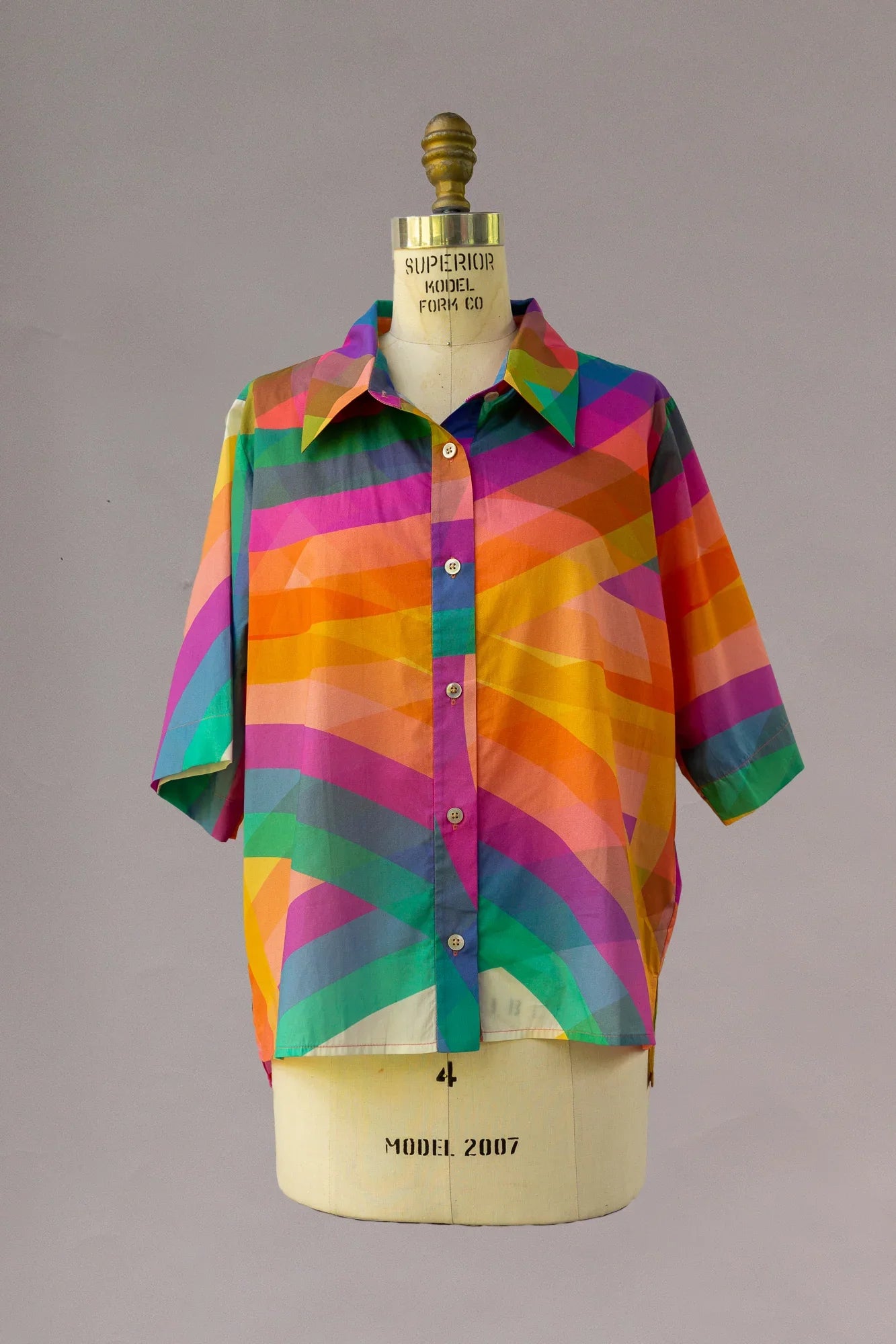Short sleeve aloha shirt with bold rainbow geometric print on mannequin