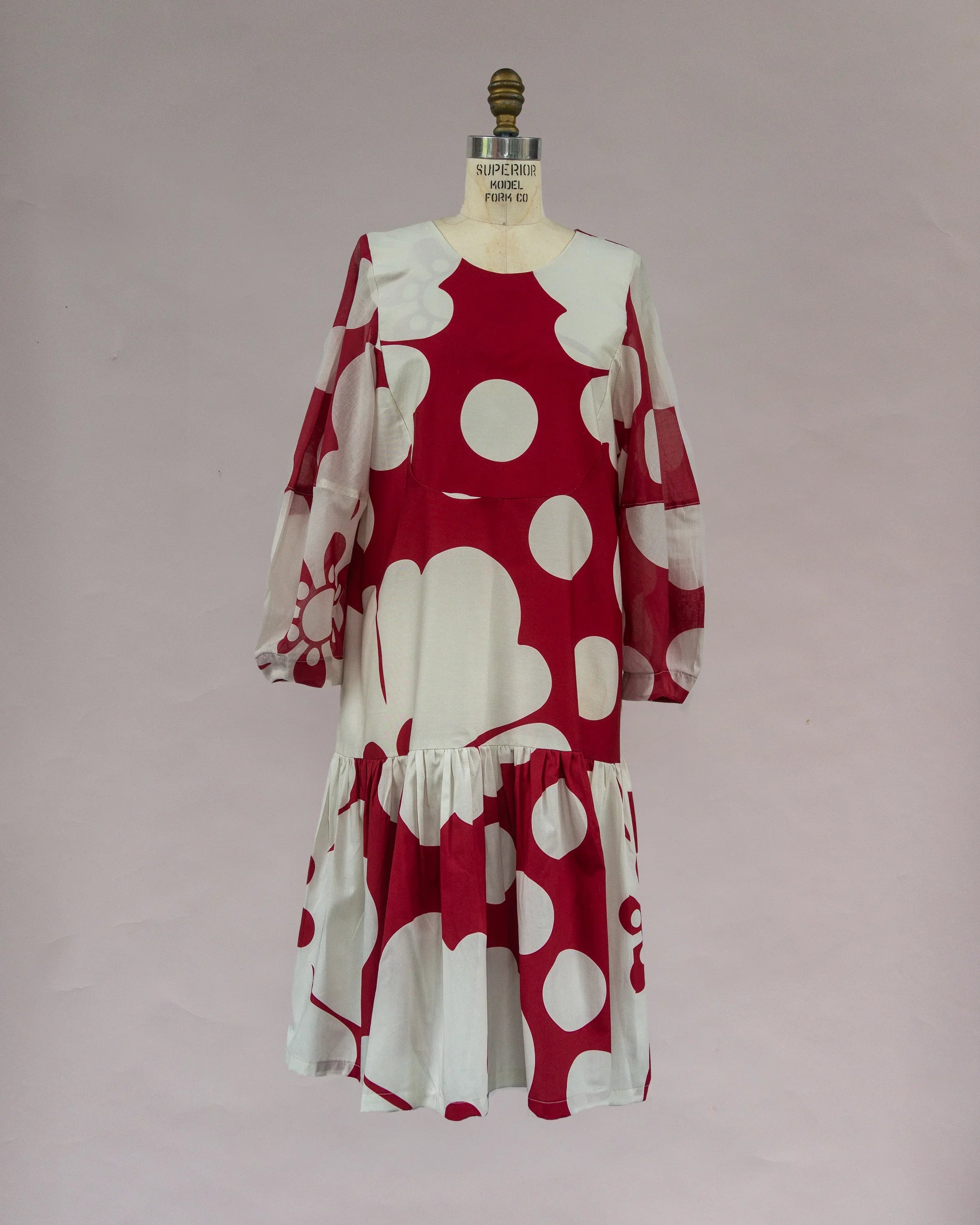 Modern mu'umu'u dress with bold red and white floral Hawaiian print on a mannequin