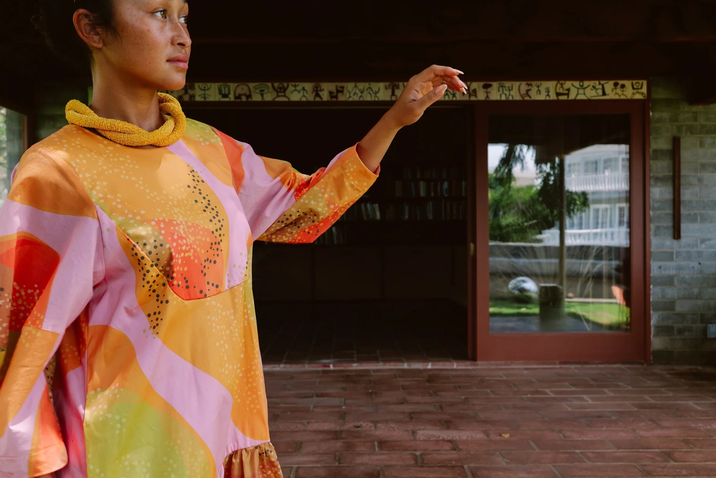 Woman wearing a modern muʻumuʻu dress with colorful abstract Hawaiian print
