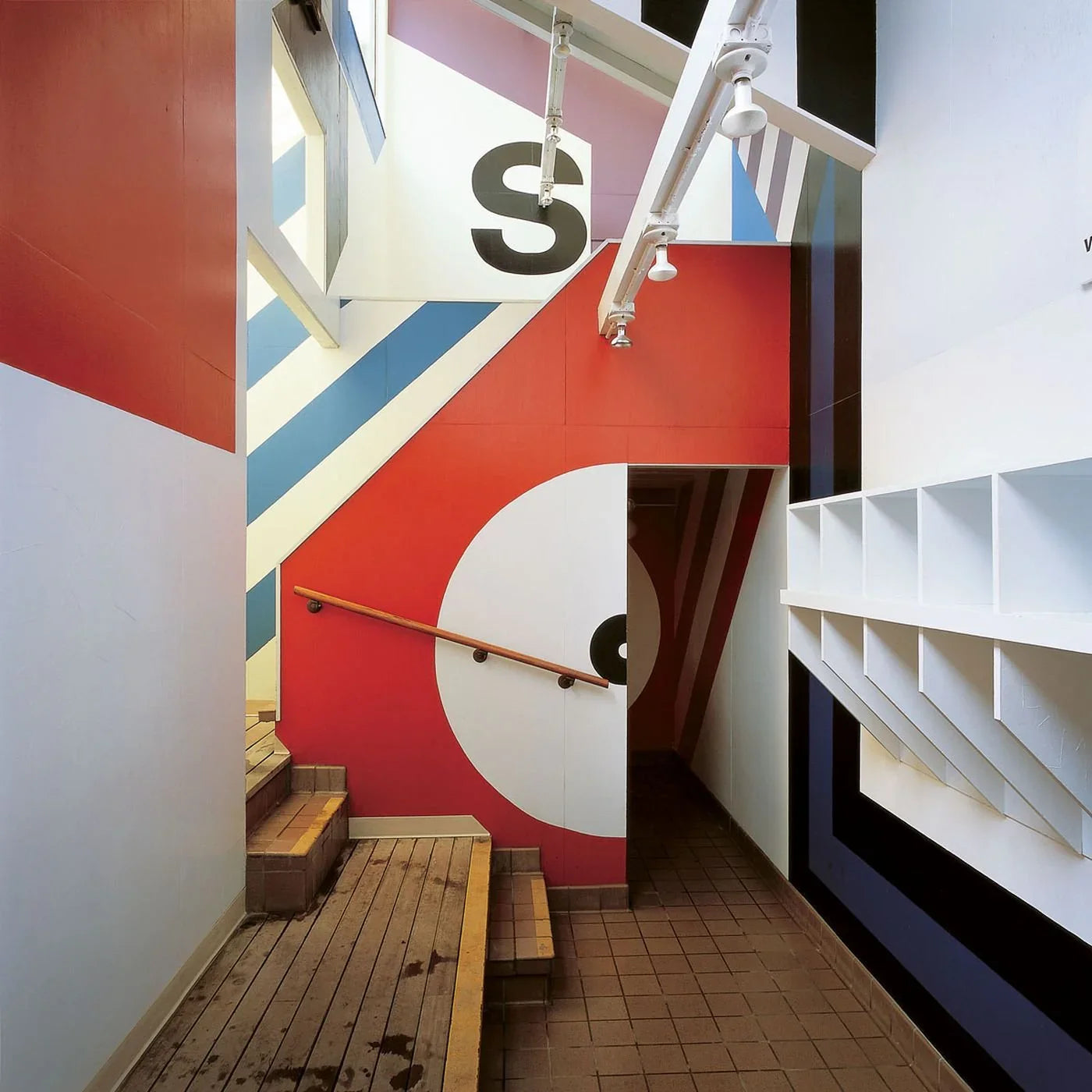 Colorful geometric staircase interior with bold wall art, abstract shapes, and letter S decor