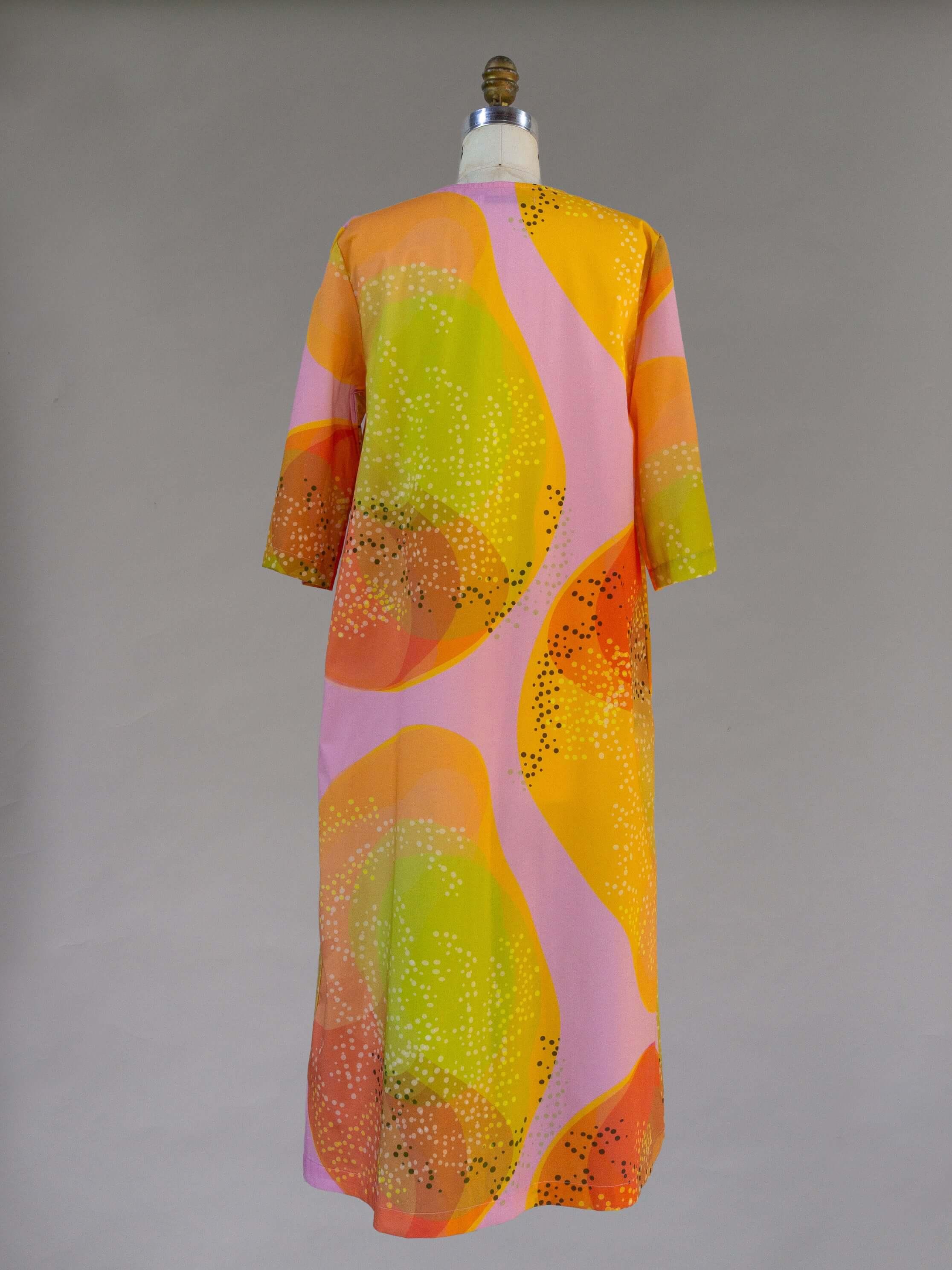 Long muumuu dress with vibrant orange, pink, and yellow abstract Hawaiian print