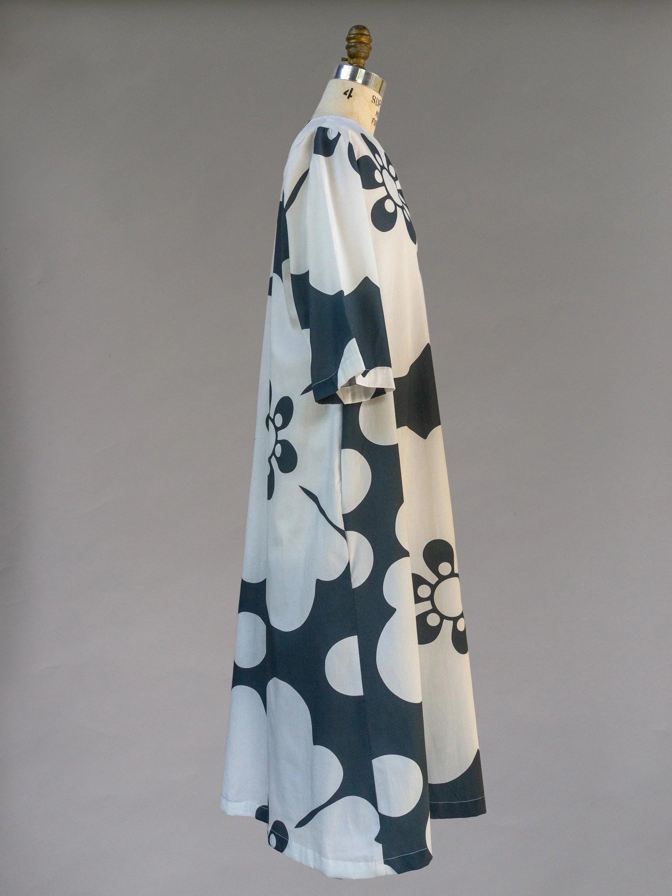 Side view of navy and white floral muumuu dress on mannequin, modern Hawaiian print