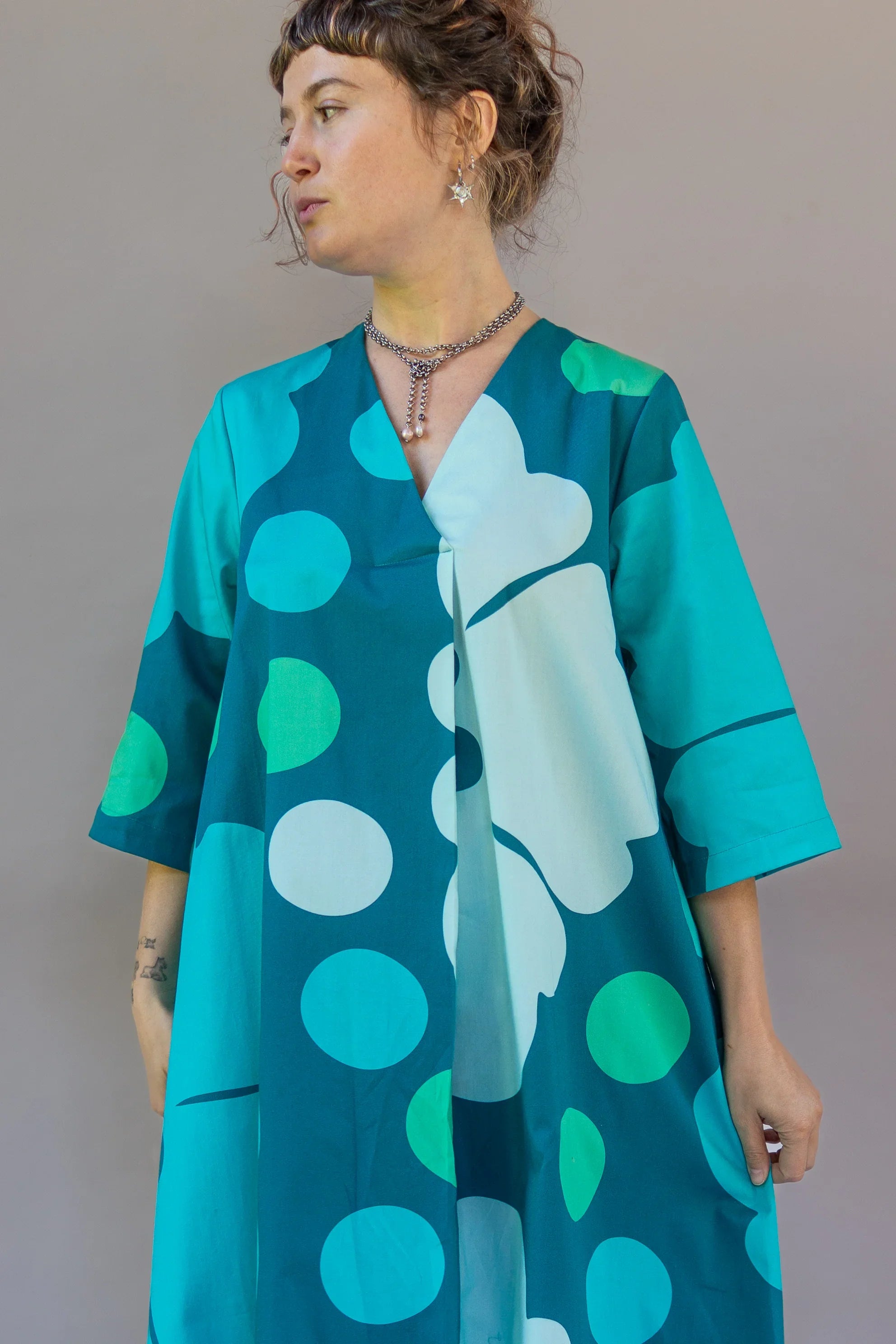 Woman wearing modern blue muumuu dress with bold ocean-inspired Hawaiian print