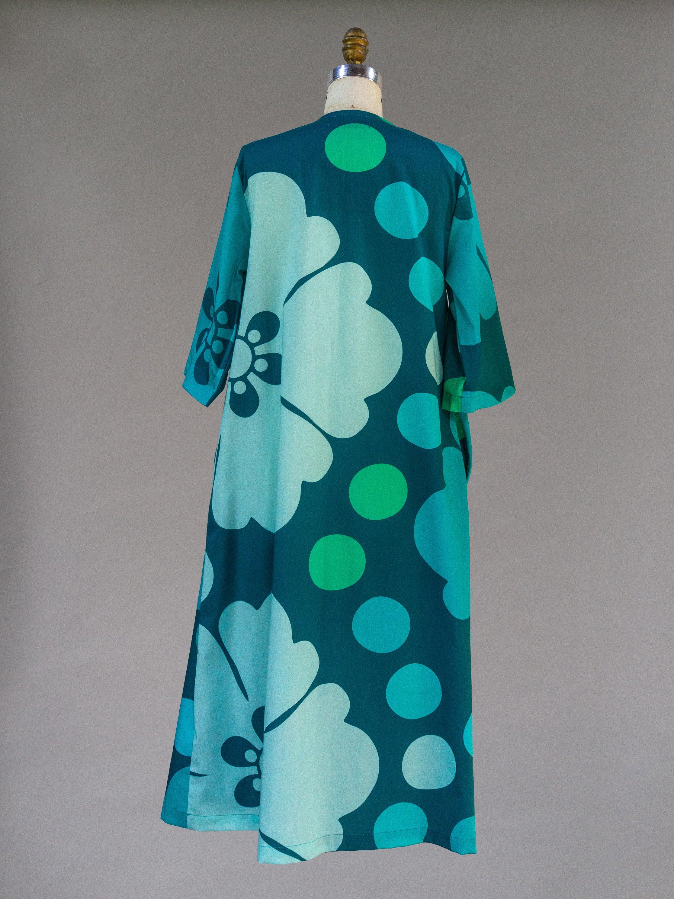 Back view of a teal mu'umu'u dress with large floral and polka dot Hawaiian print