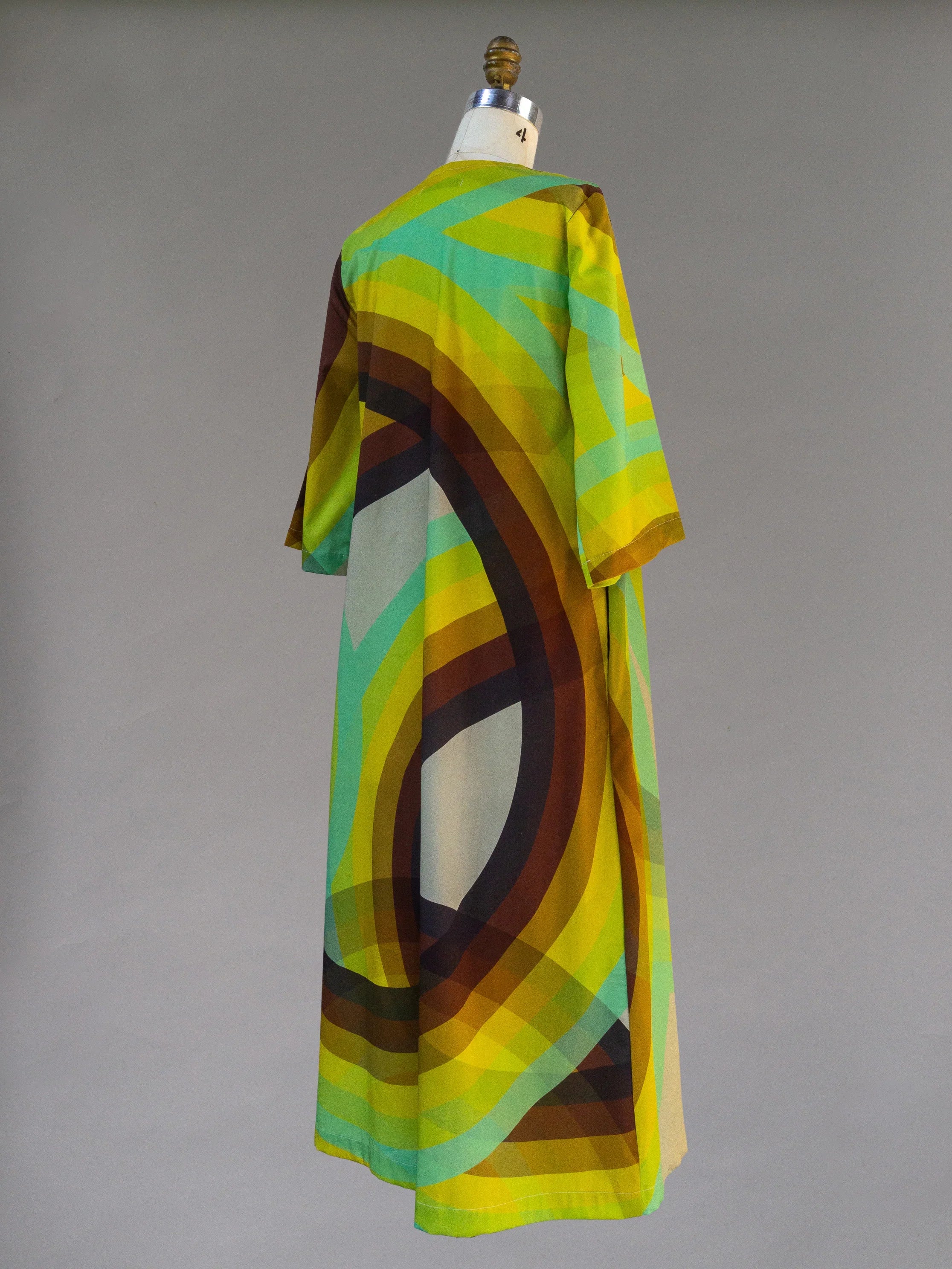 Colorful modern muʻumuʻu dress with geometric rainbow print on mannequin.
