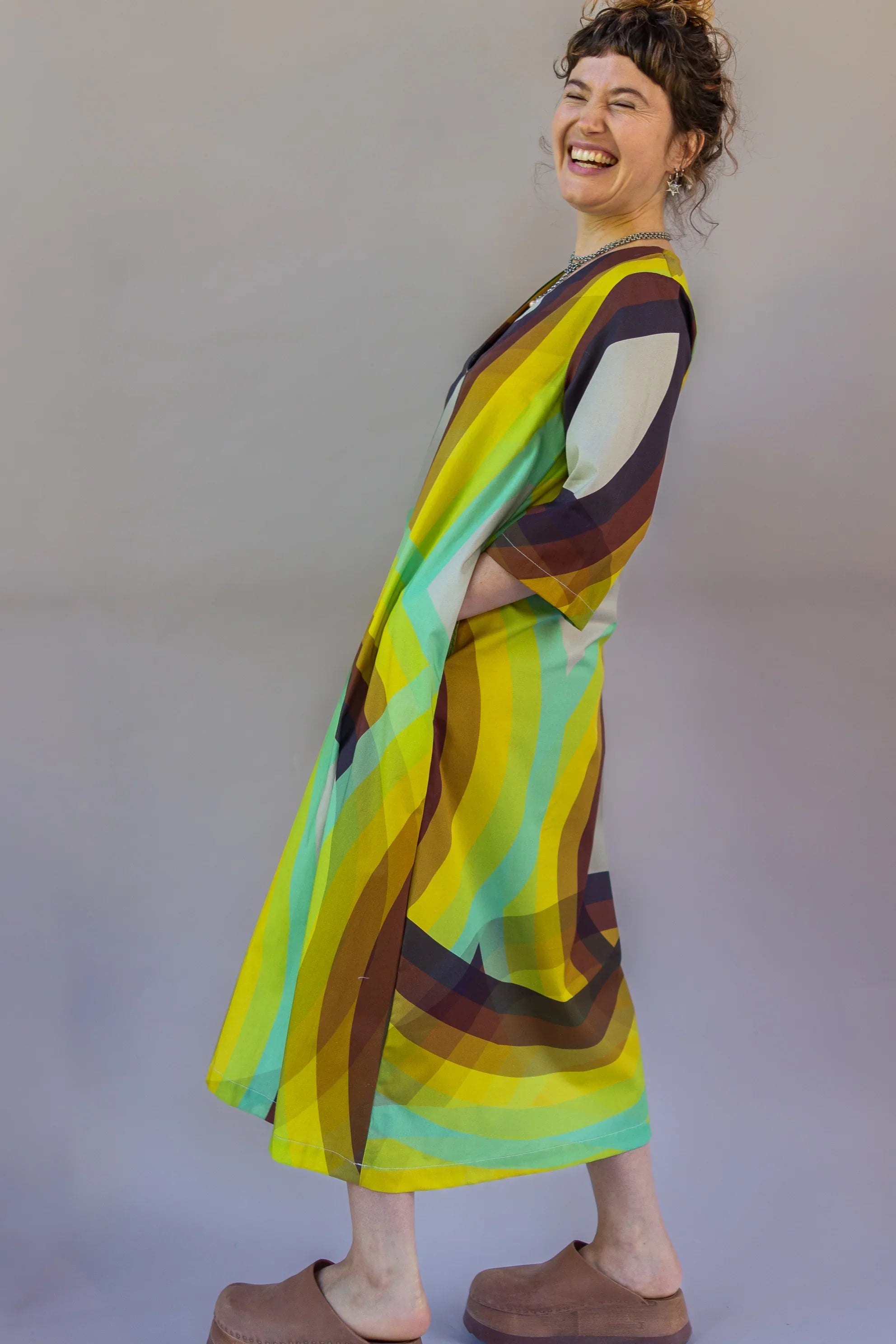 Woman wearing modern mu'umu'u dress with bold rainbow geometric Hawaiian print