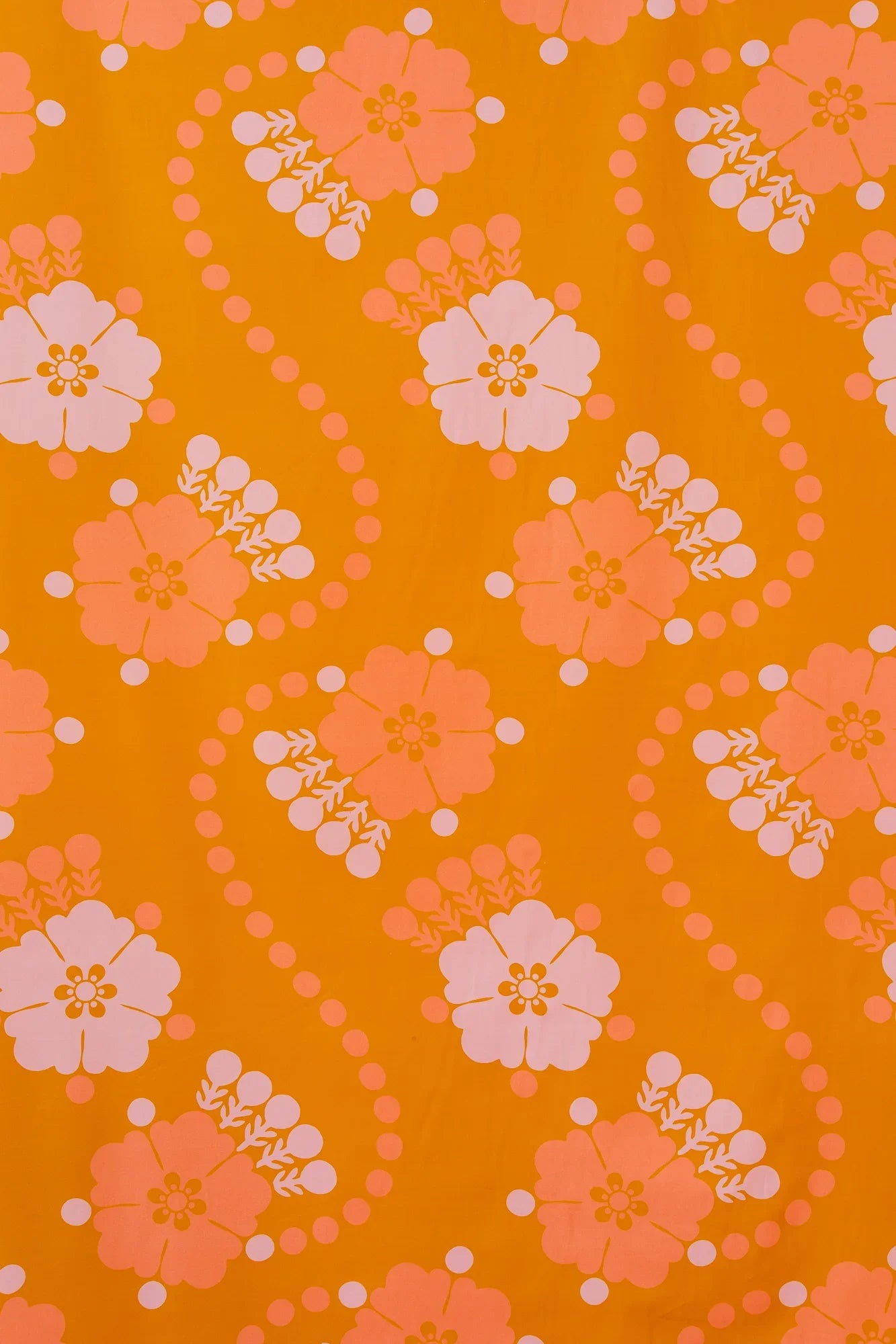 Retro floral Hawaiian fabric with pink and peach flowers on an orange background
