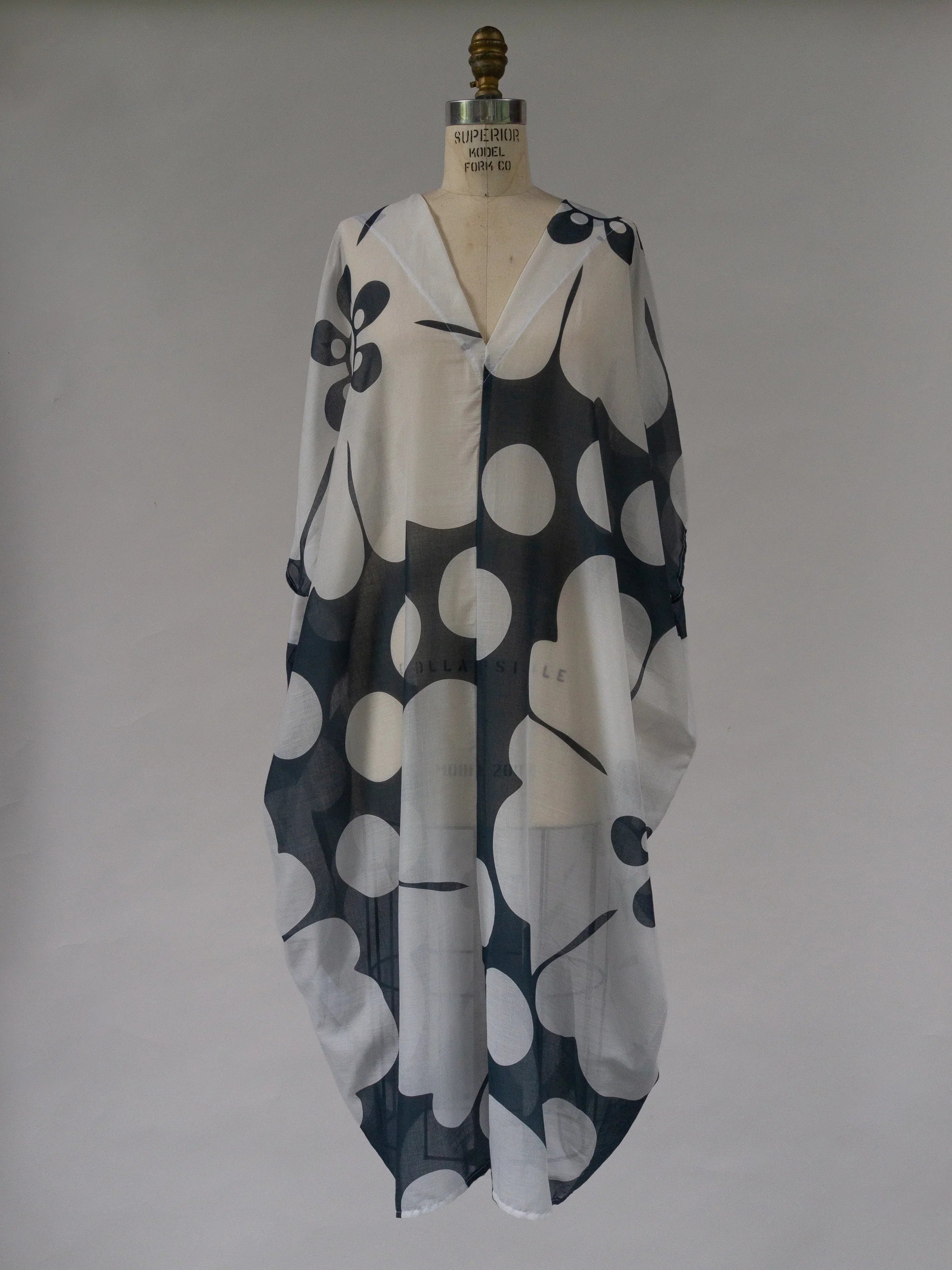 Navy and white oversized pareo kaftan with bold abstract floral print on mannequin