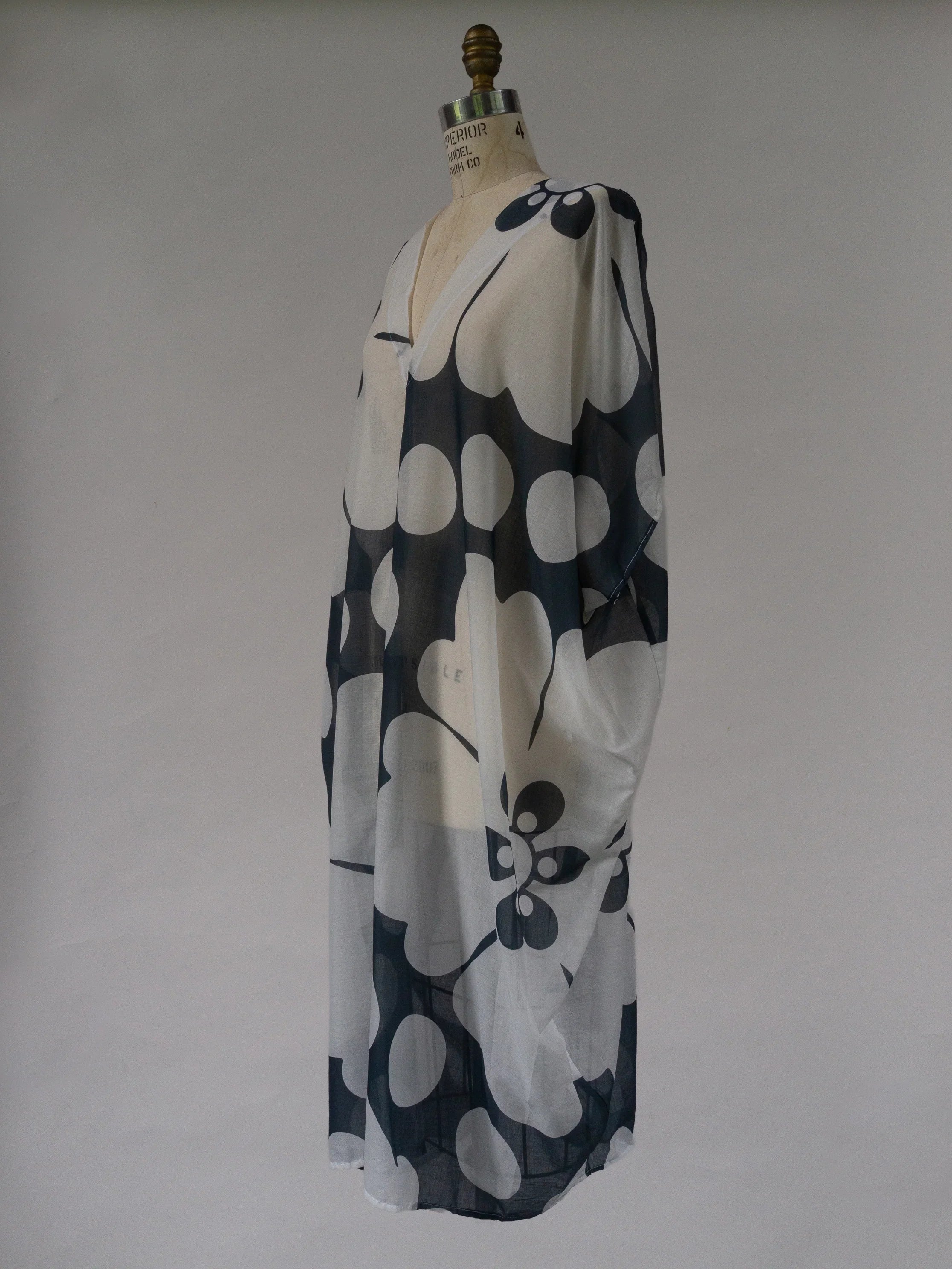 Sheer navy and white floral kaftan dress with oversized Hawaiian print on mannequin