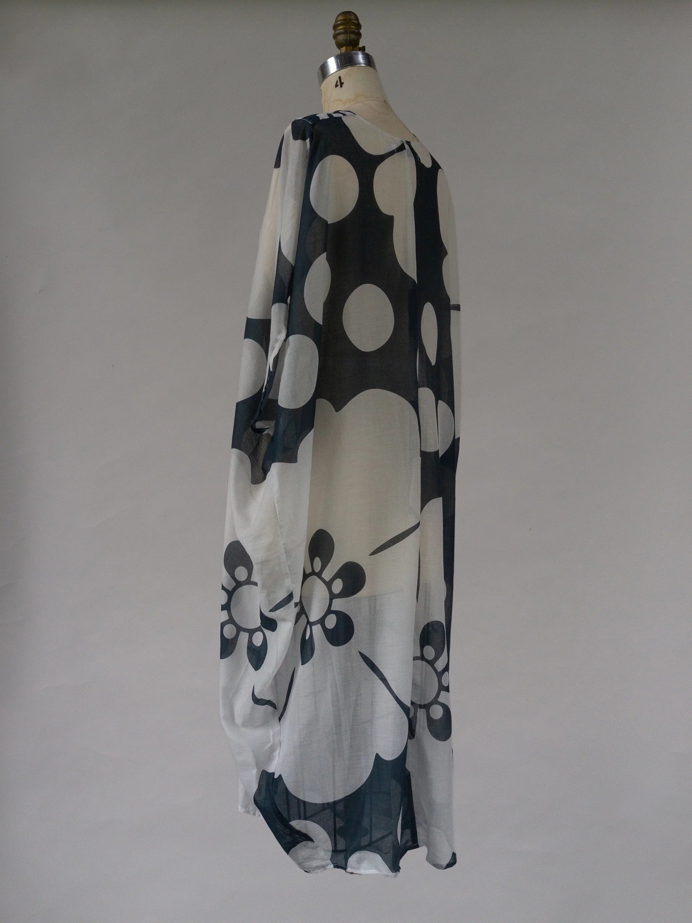 Navy floral print sheer kaftan dress with oversized polka dots on mannequin