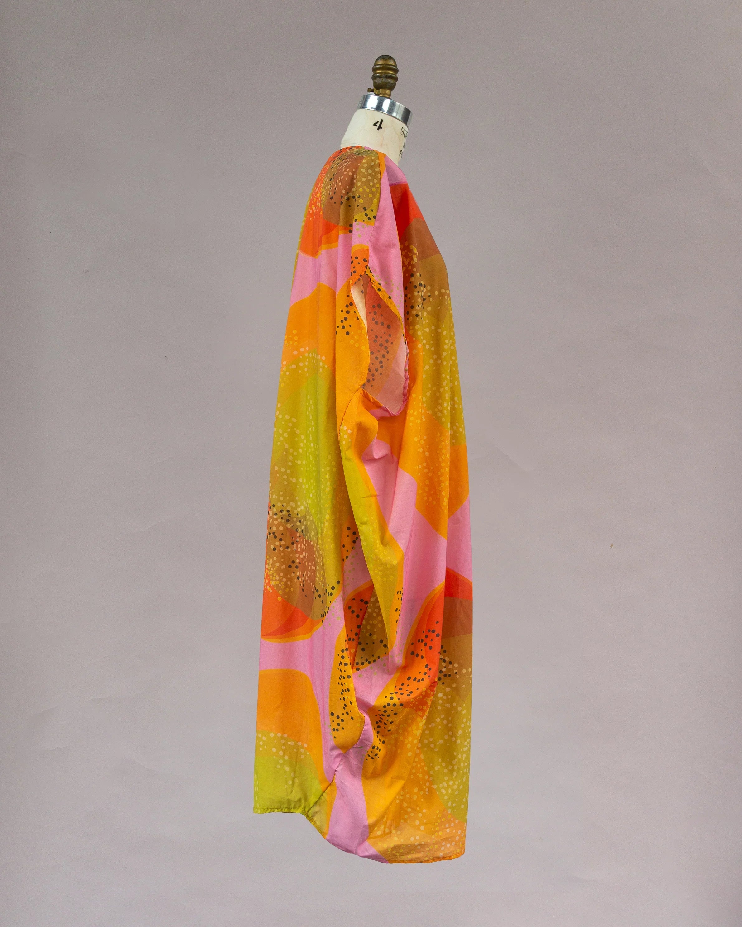 Colorful Hawaiian print kaftan dress in orange, pink, and yellow with abstract patterns