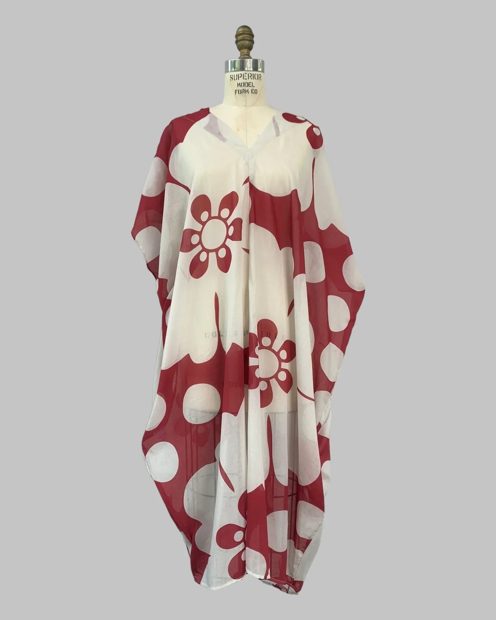 Sheer red and white jumbo pareo kaftan with bold floral Hawaiian print on mannequin