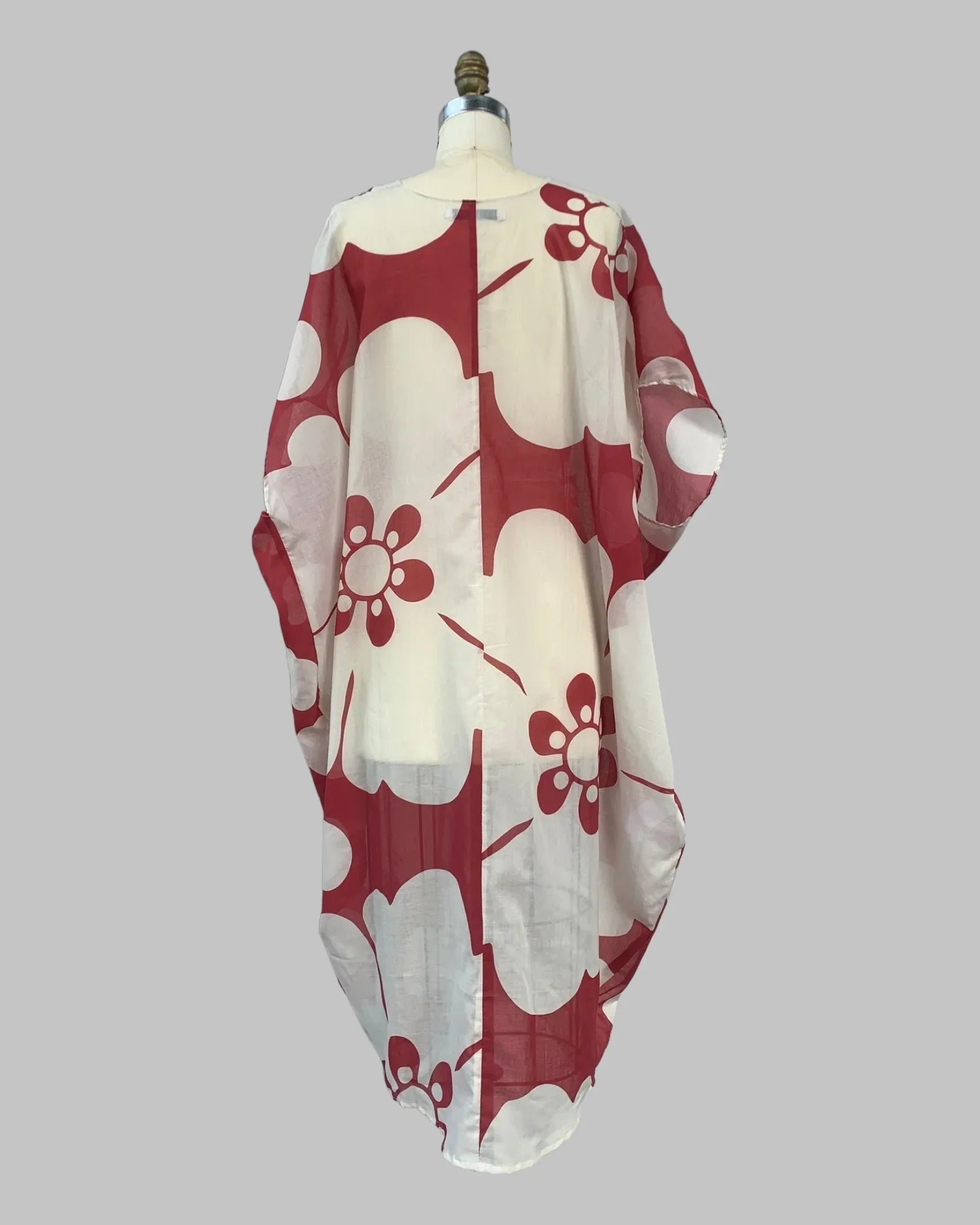 Red and white oversized kaftan pareo with bold floral print, displayed on mannequin