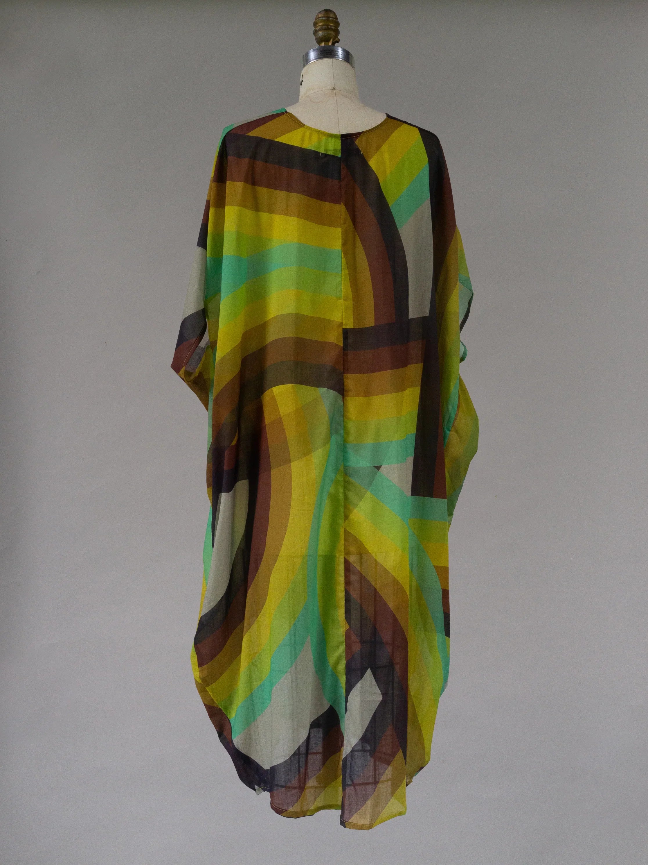 Flowy kaftan dress with rainbow Saturn-inspired geometric stripes on a mannequin