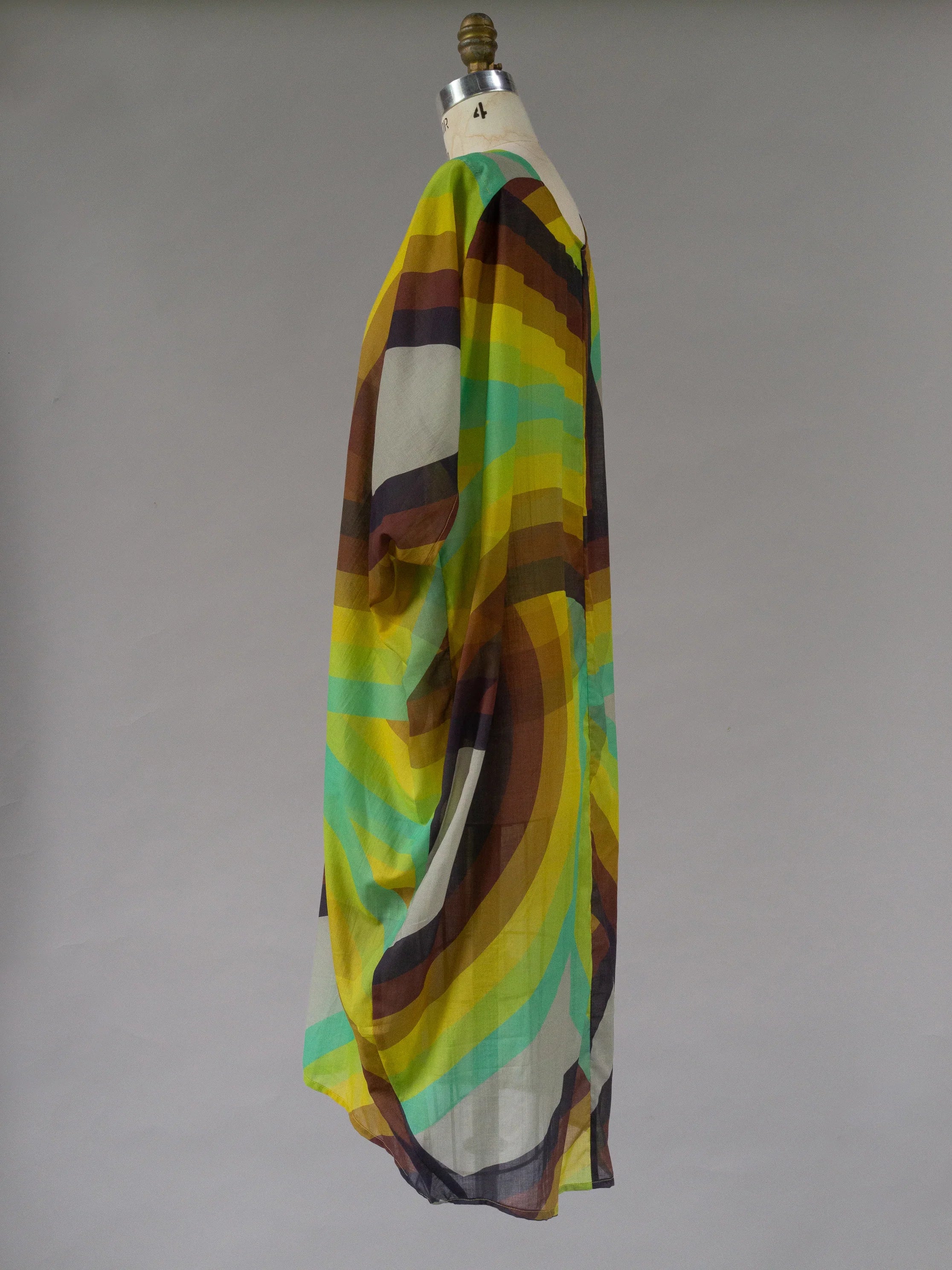 Modern sheer kaftan dress with colorful rainbow geometric print on mannequin