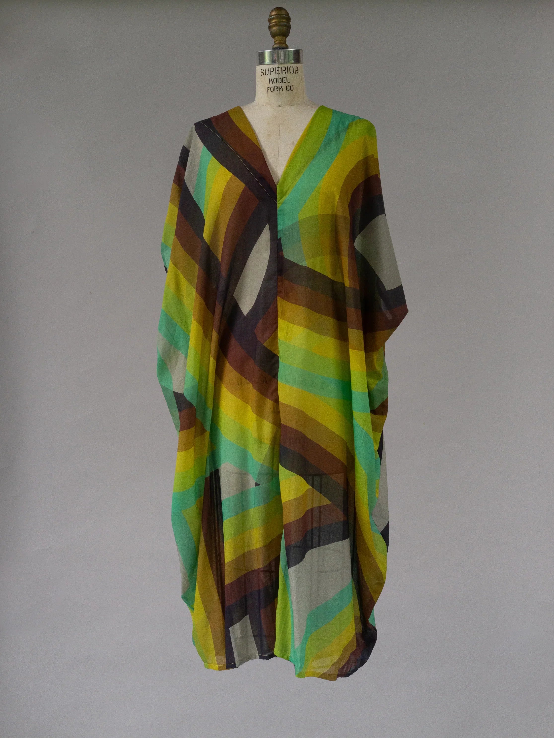 Colorful geometric print kaftan dress with flowy silhouette on mannequin