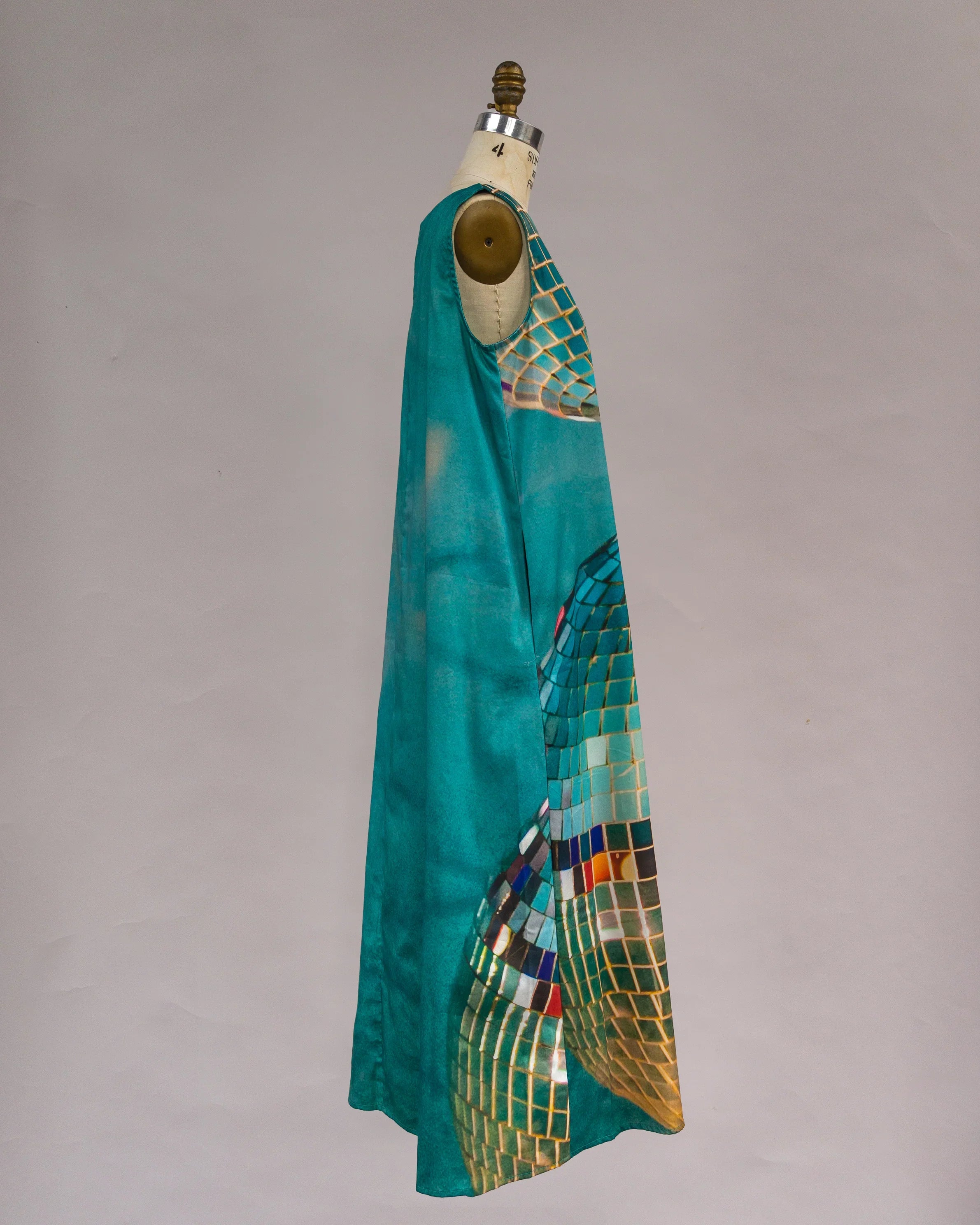 Teal modern mu'umu'u dress with artistic mosaic print, sleeveless, on mannequin