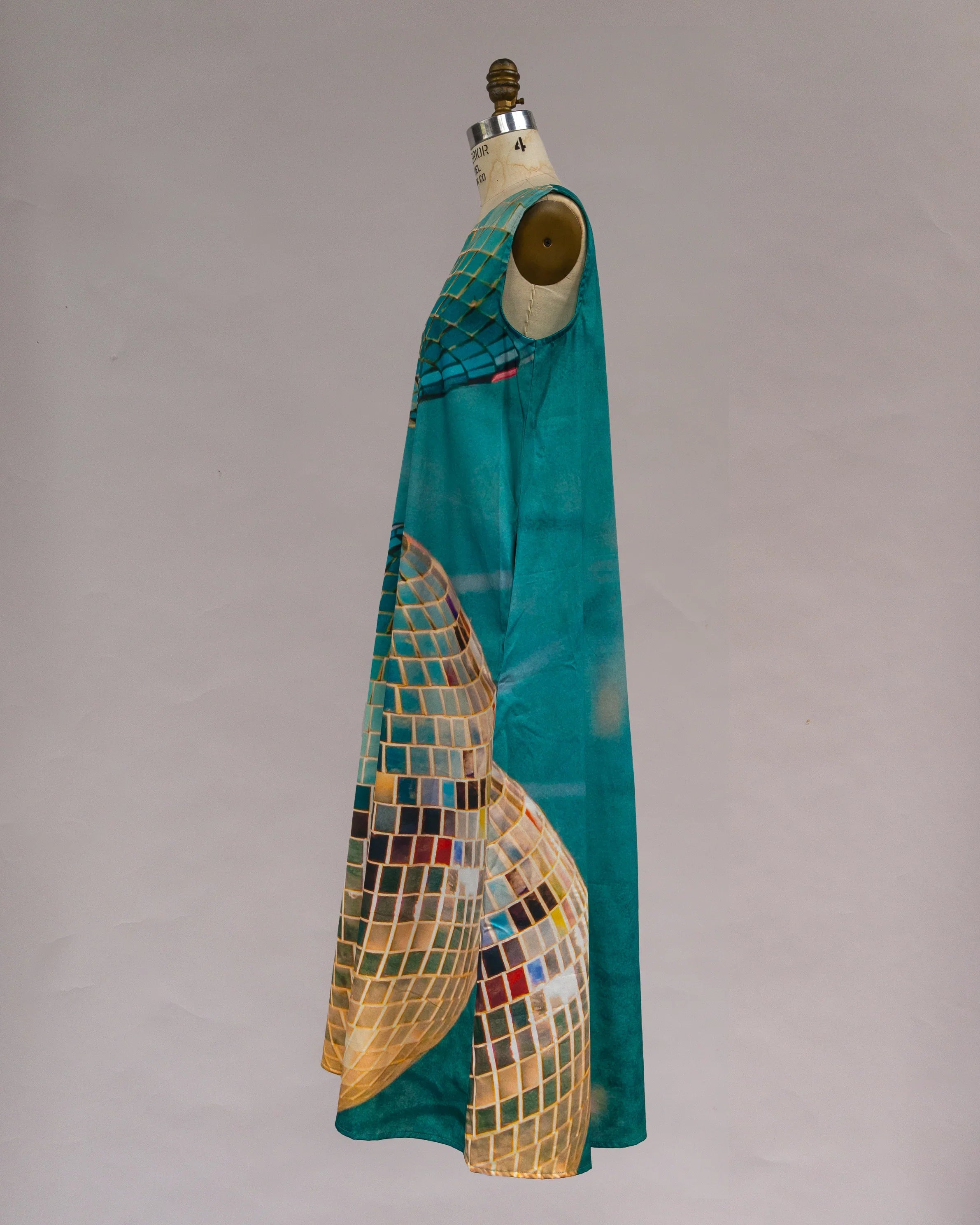Sleeveless teal mu'umu'u dress with abstract gold mosaic print on mannequin