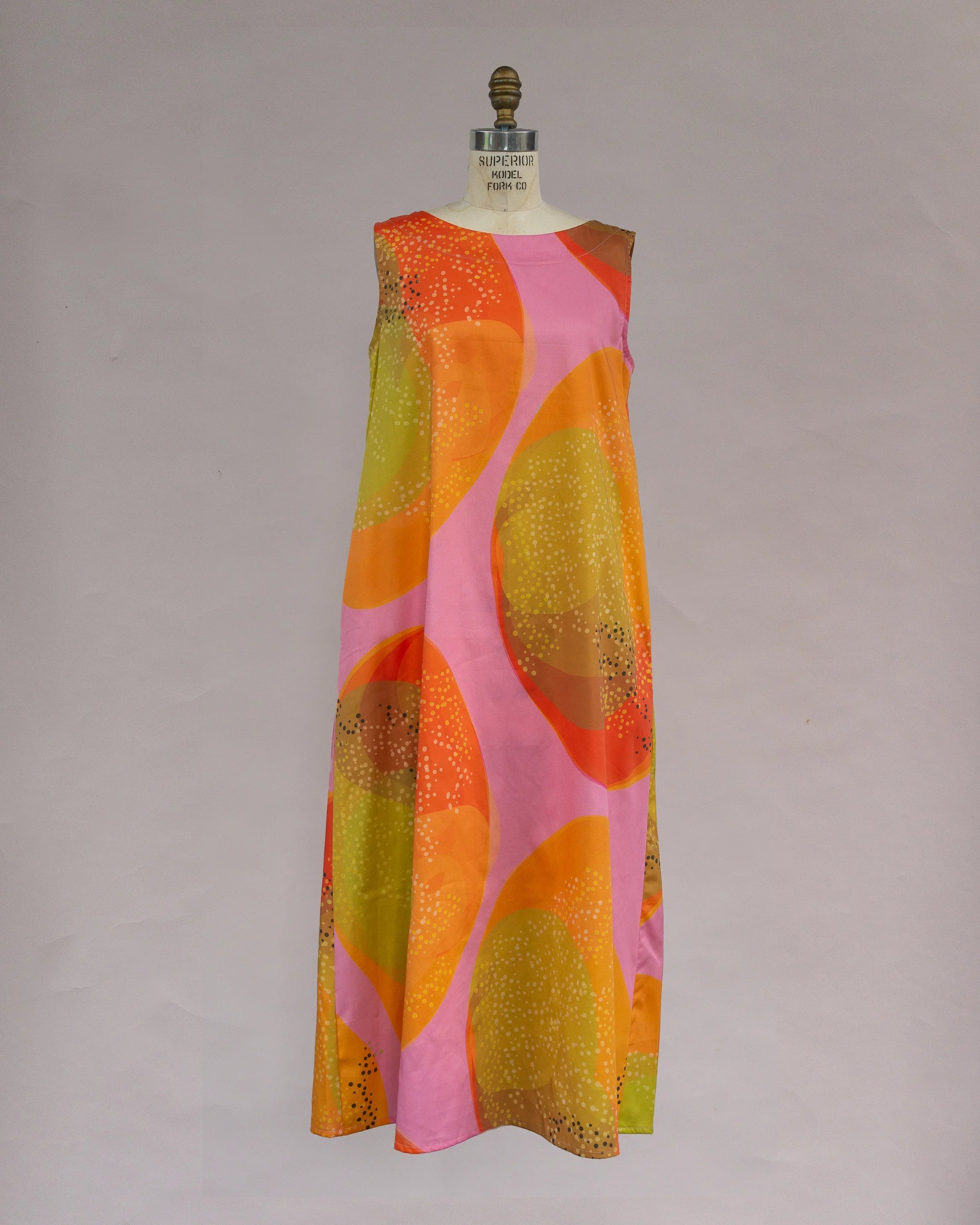 Sleeveless pink muumuu dress with bold orange and yellow abstract Hawaiian print