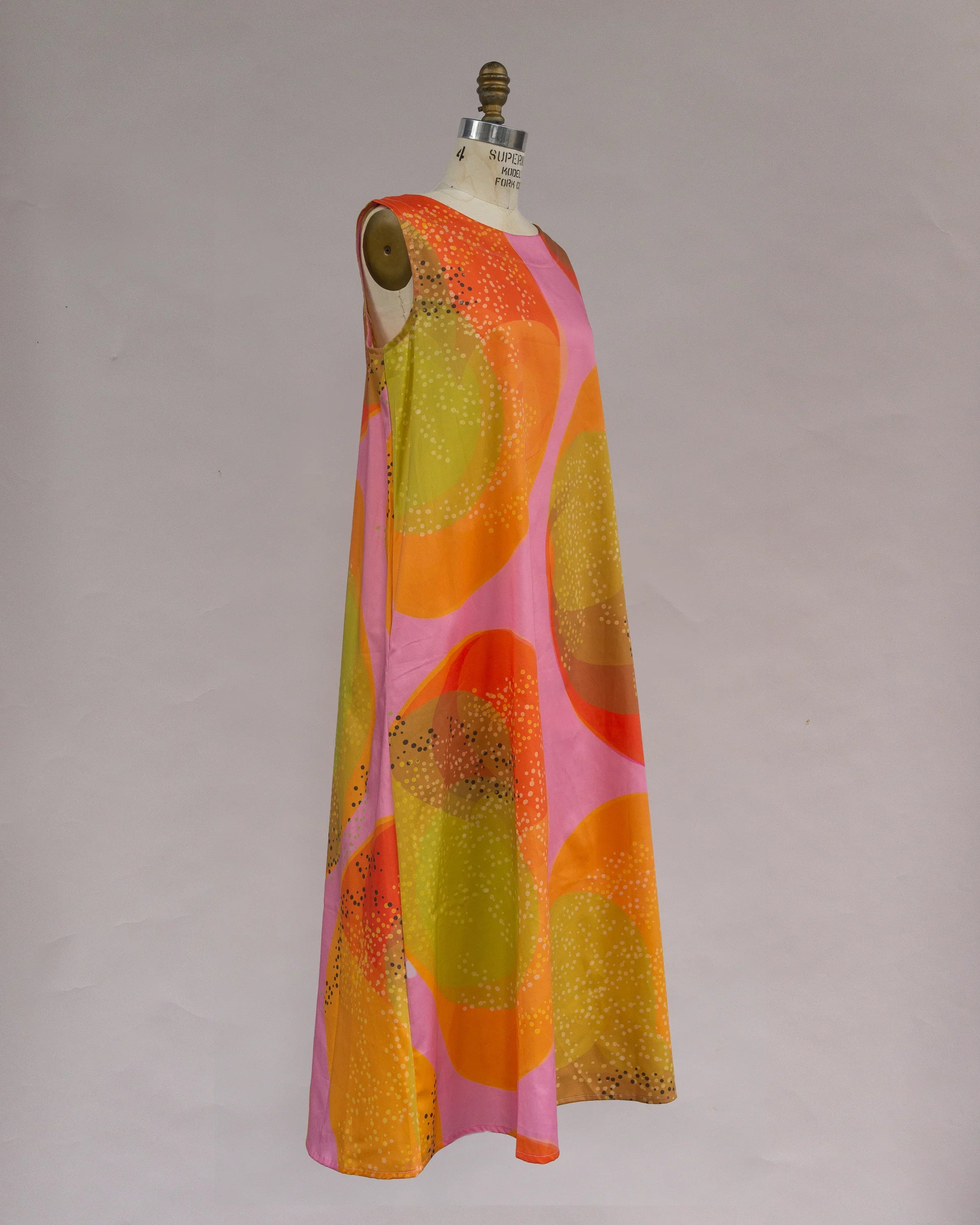 Sleeveless modern muumuu dress with vibrant orange, pink, and green abstract print