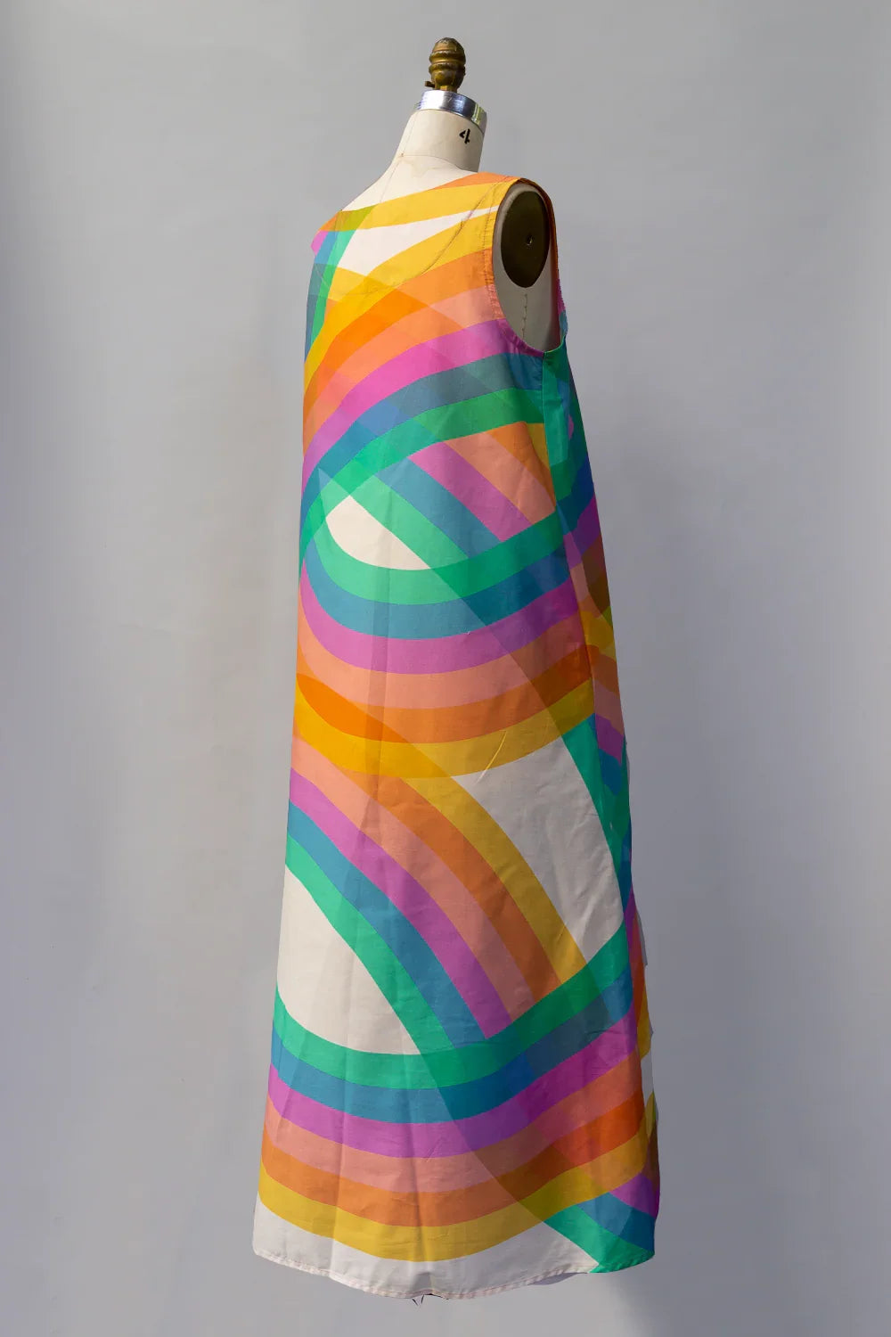 Sleeveless long muumuu dress with colorful rainbow swirl pattern on mannequin