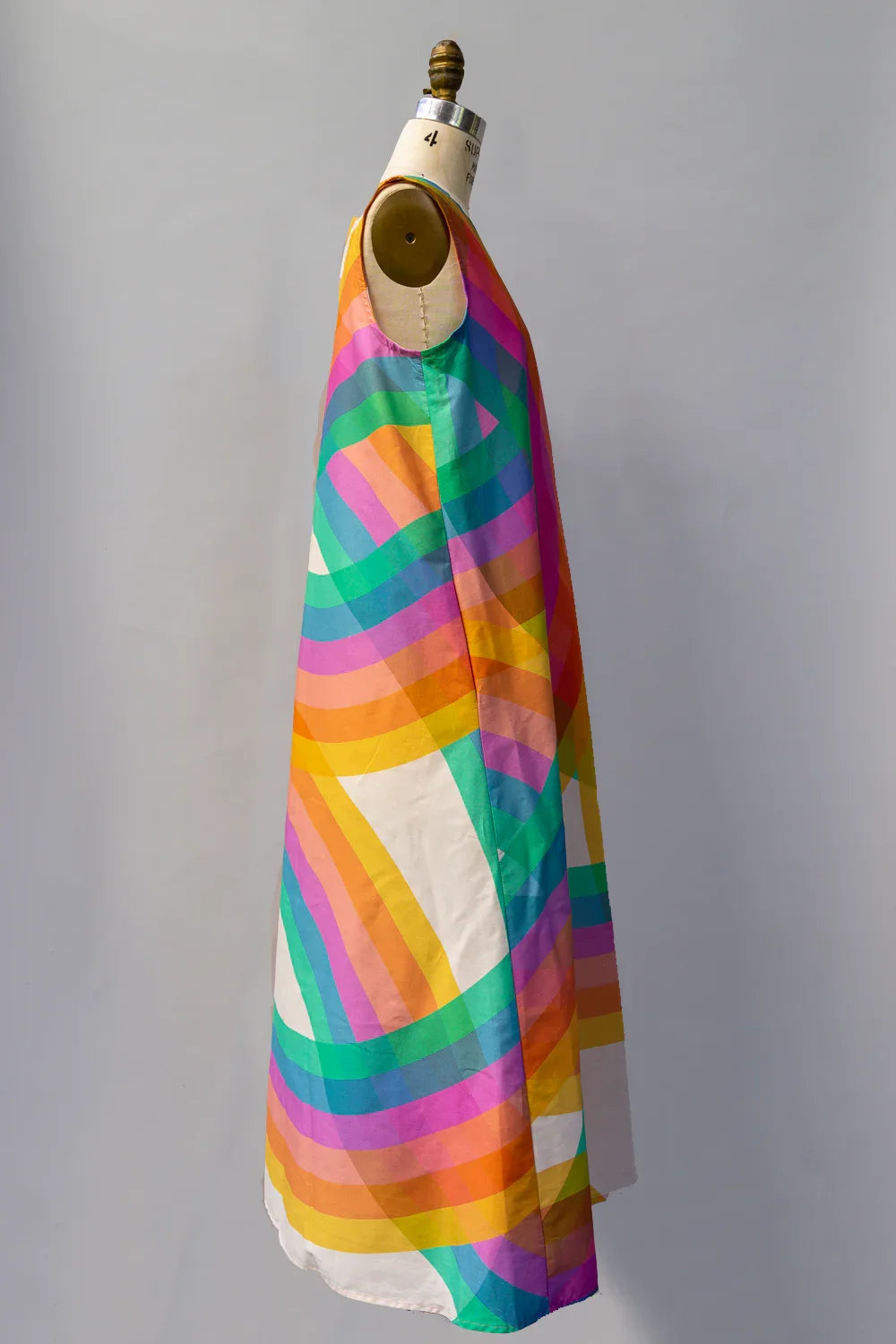 Sleeveless long dress with colorful rainbow-inspired geometric print on mannequin