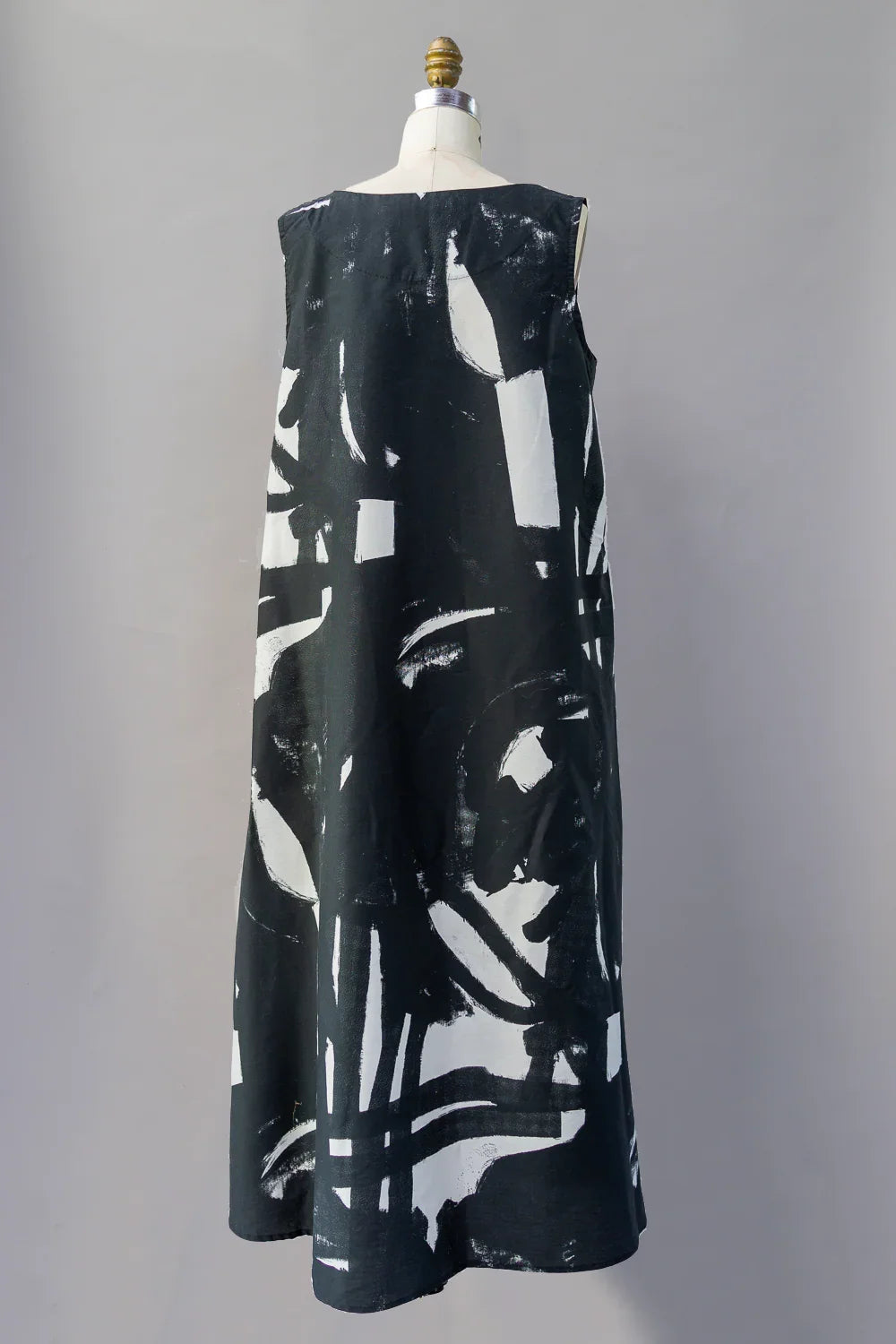 Long black dress with bold abstract white print, sleeveless, shown on mannequin