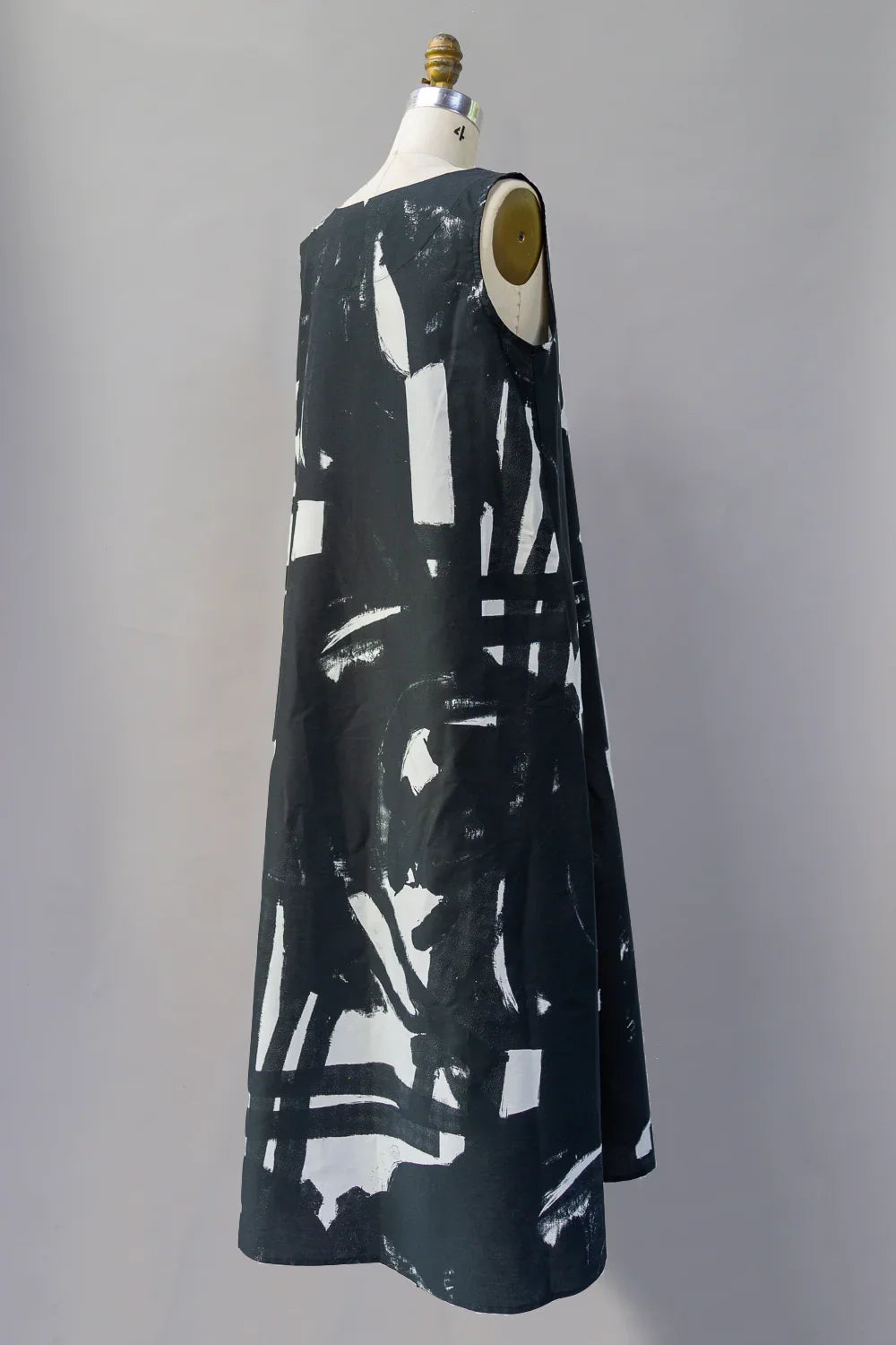 Sleeveless long black mu'umu'u dress with bold white abstract print on mannequin
