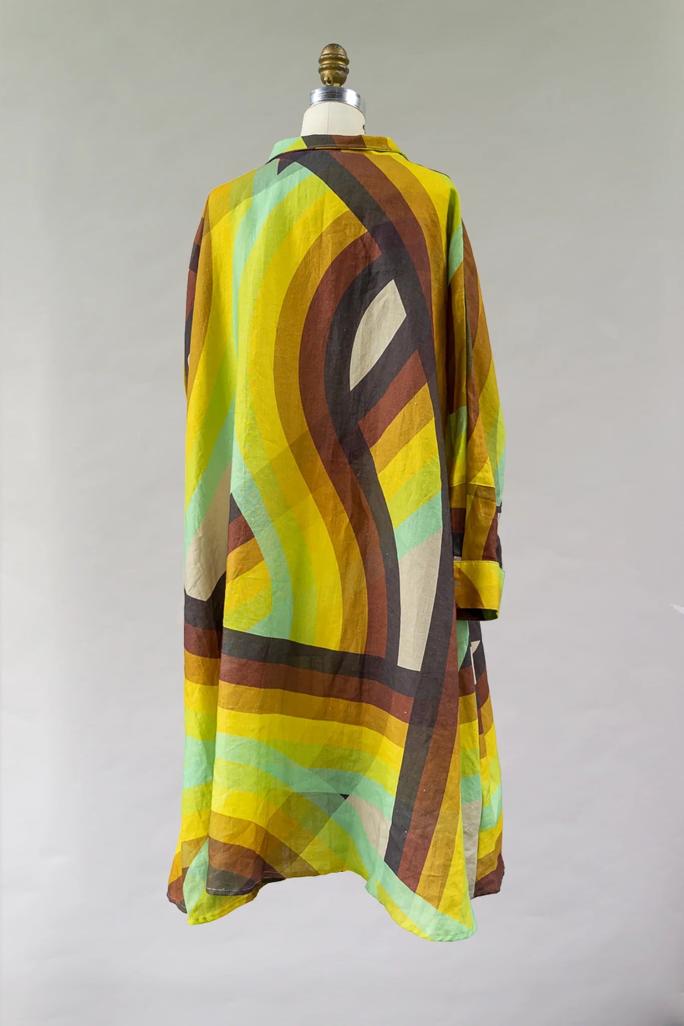 Back view of a flowy dress with bold yellow, brown, and green geometric print