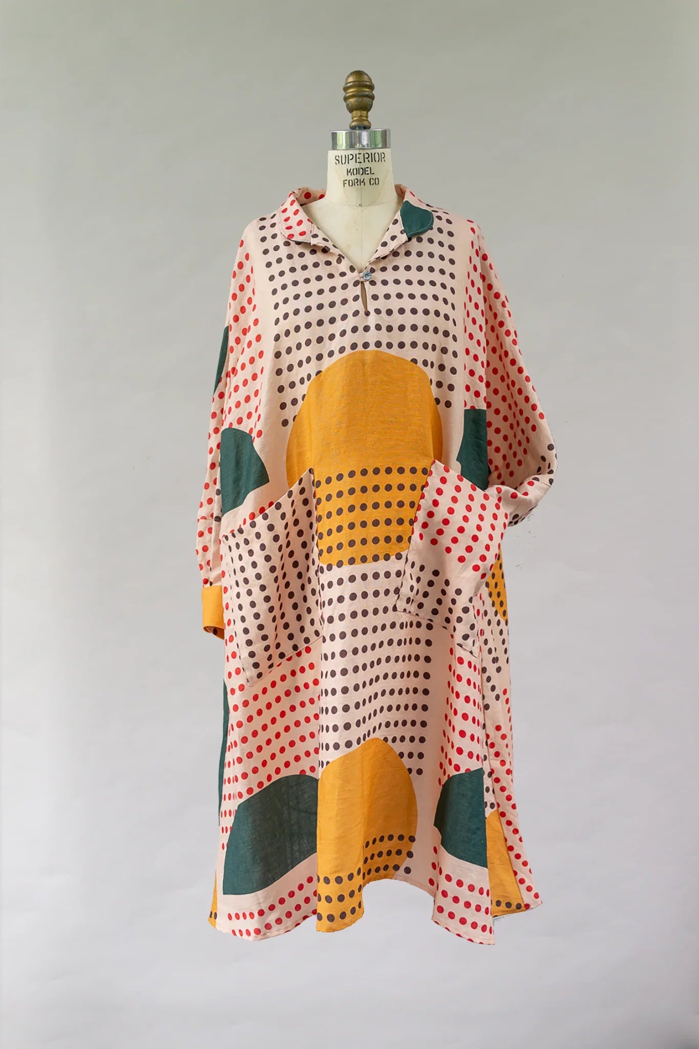 Modern mu'umu'u dress with sunrise-inspired polka dot and geometric print on mannequin