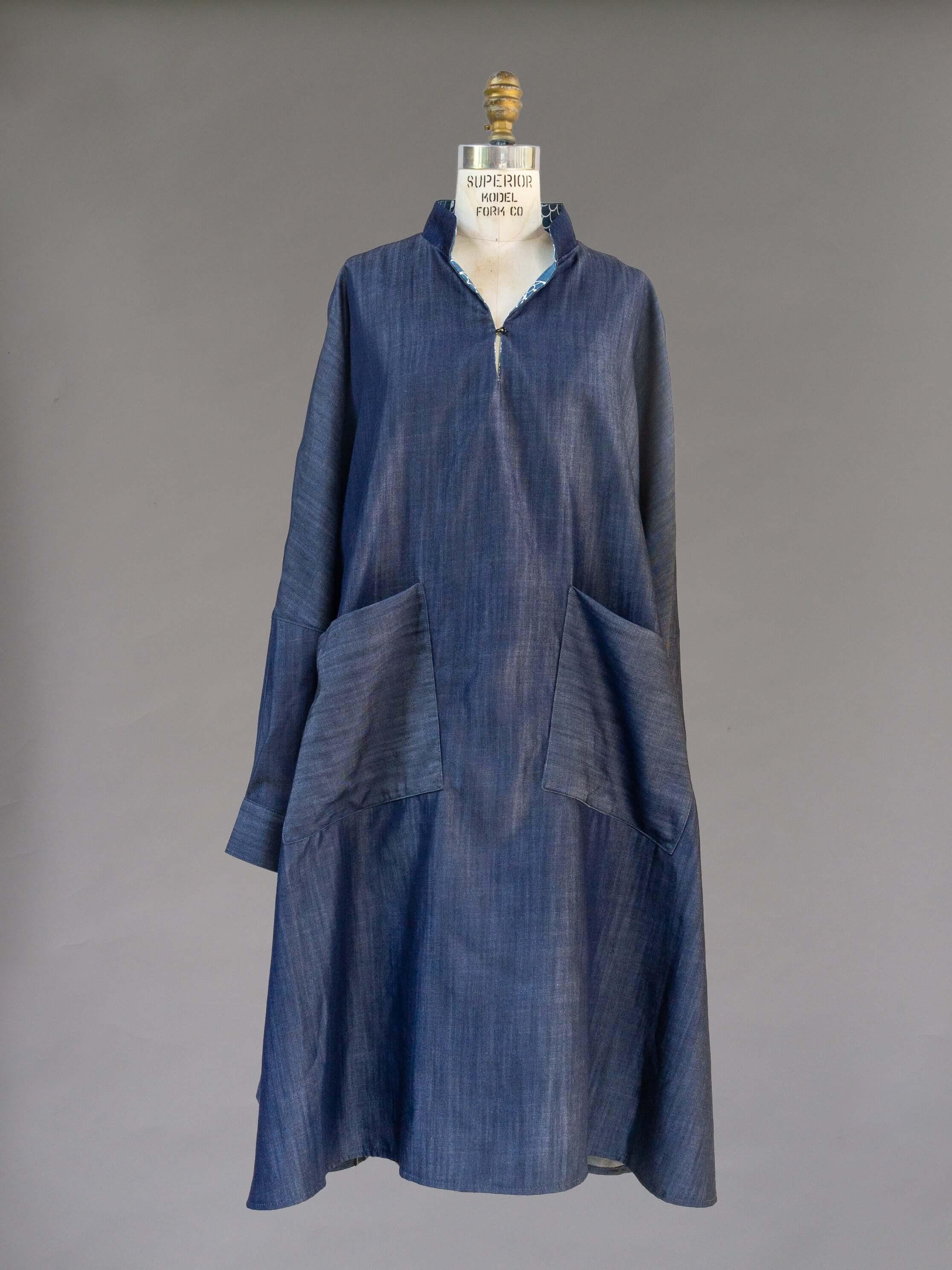 Denim muumuu dress with front pockets and split neckline on dress form