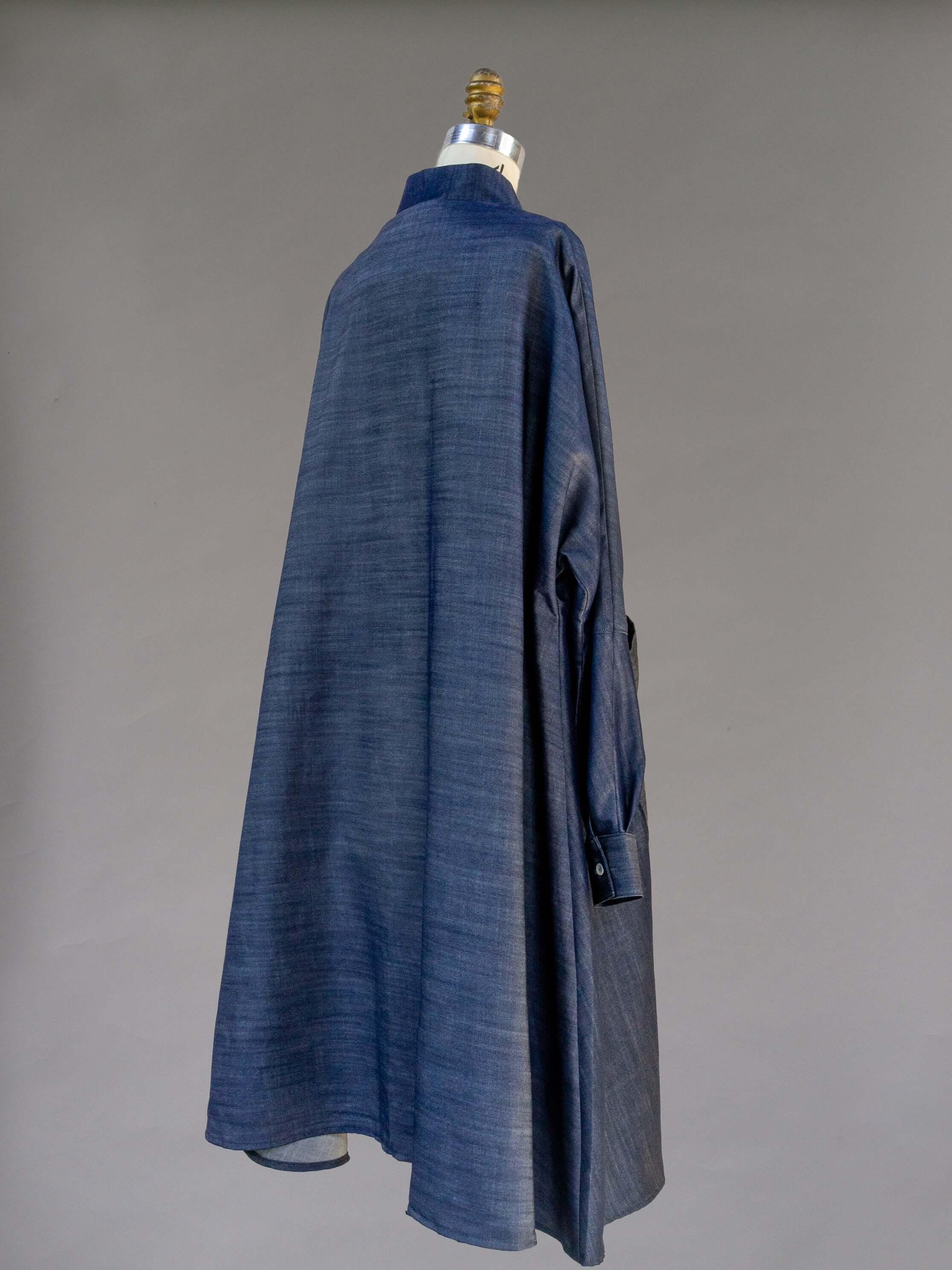 Back view of a blue denim mu'umu'u dress with long sleeves on a mannequin
