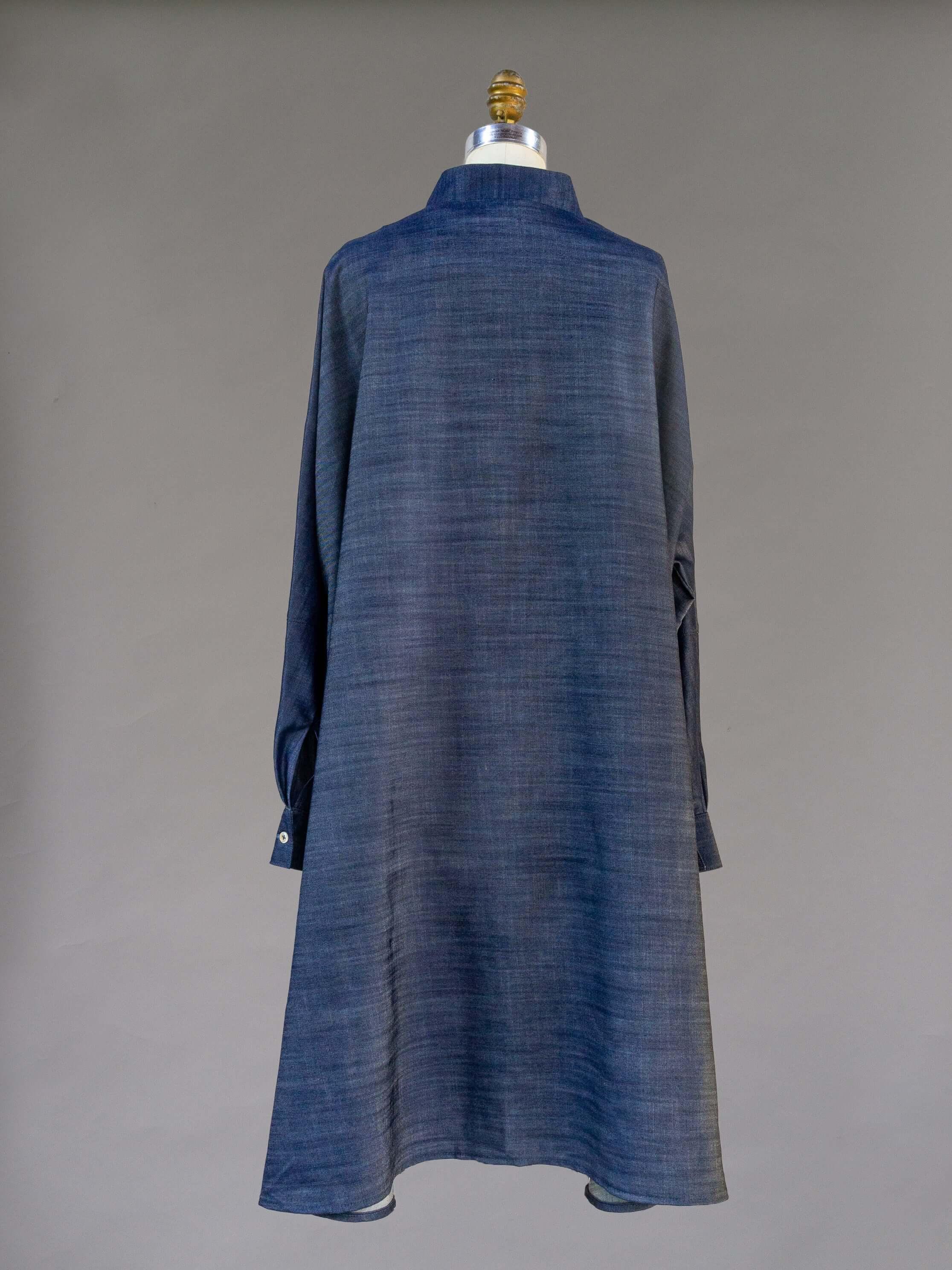 Back view of a long sleeve denim dress on a mannequin against a gray background