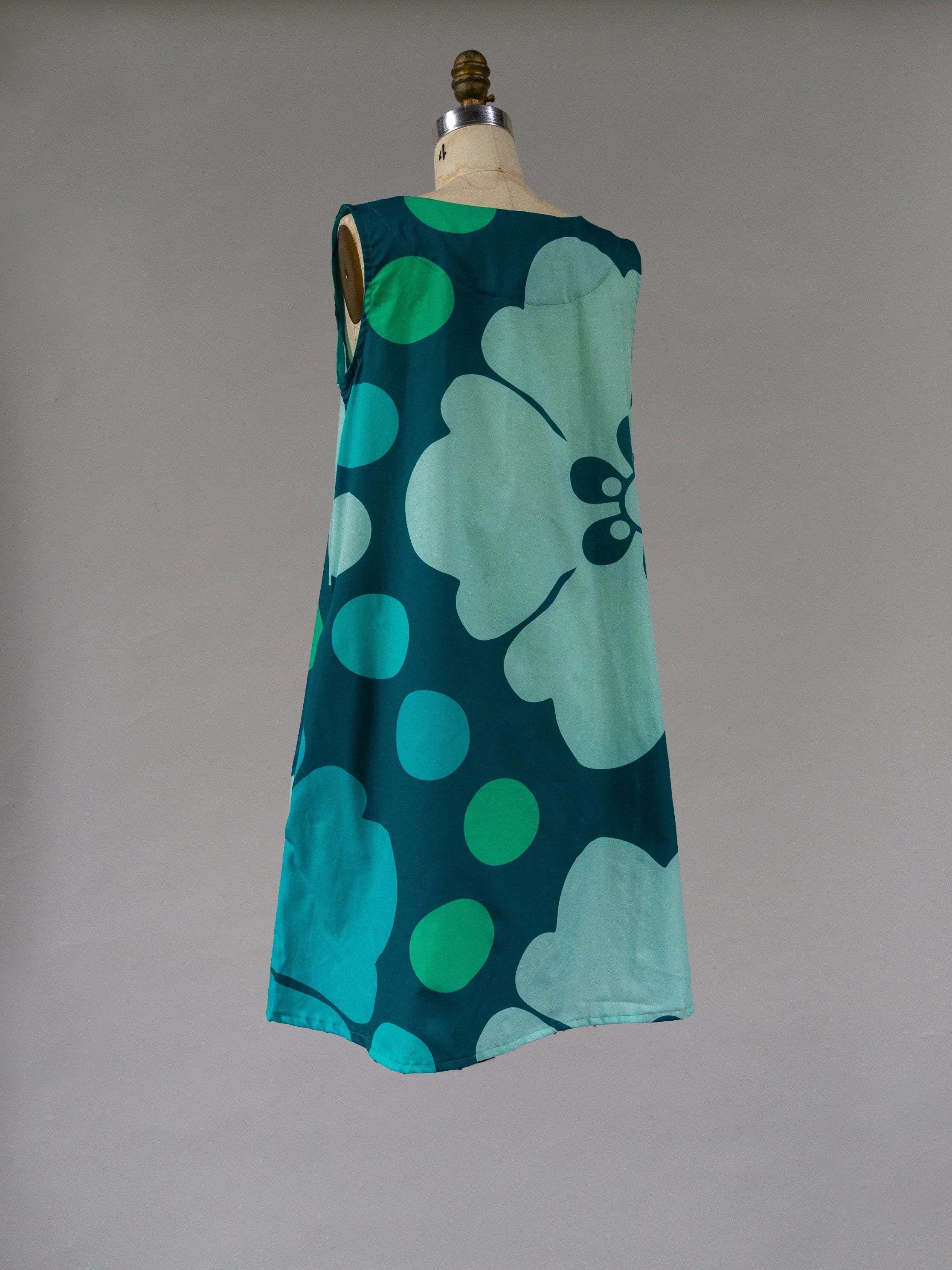 Sleeveless teal muumuu dress with large floral and polka dot Hawaiian print