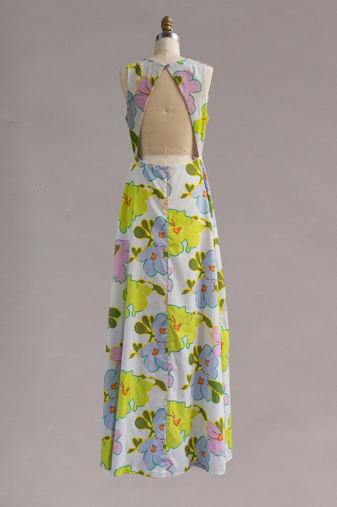 Back of sleeveless muumuu dress with open back and large pastel floral Hawaiian print