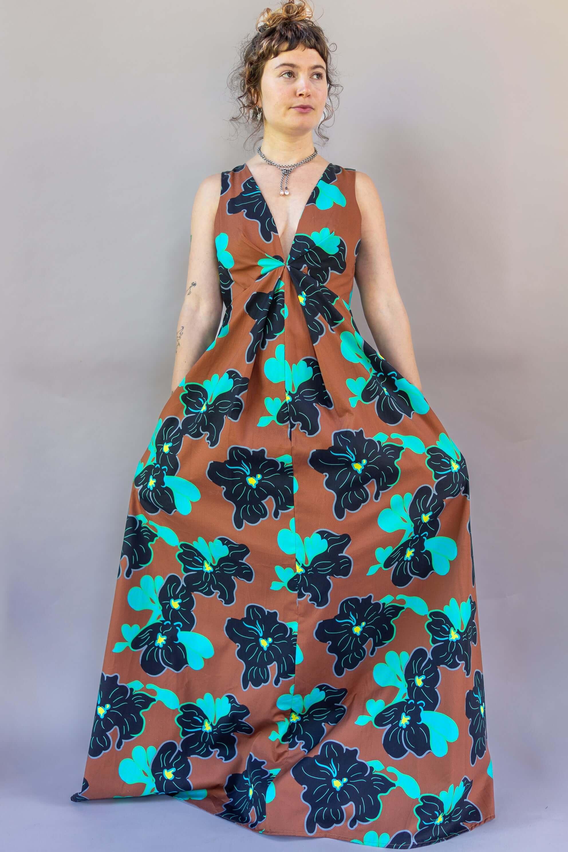 Model showcasing the Origami Dress 1961 Chestnut with a deep plunge and floral design, perfect for special occasions.