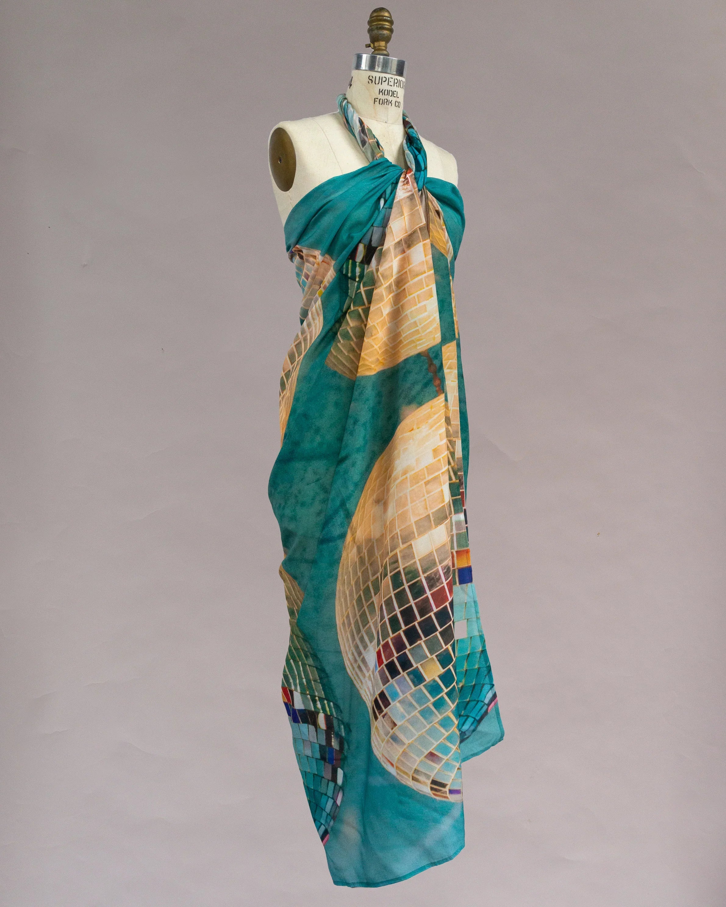 Teal and gold pareo with mosaic print draped on mannequin, modern Hawaiian style