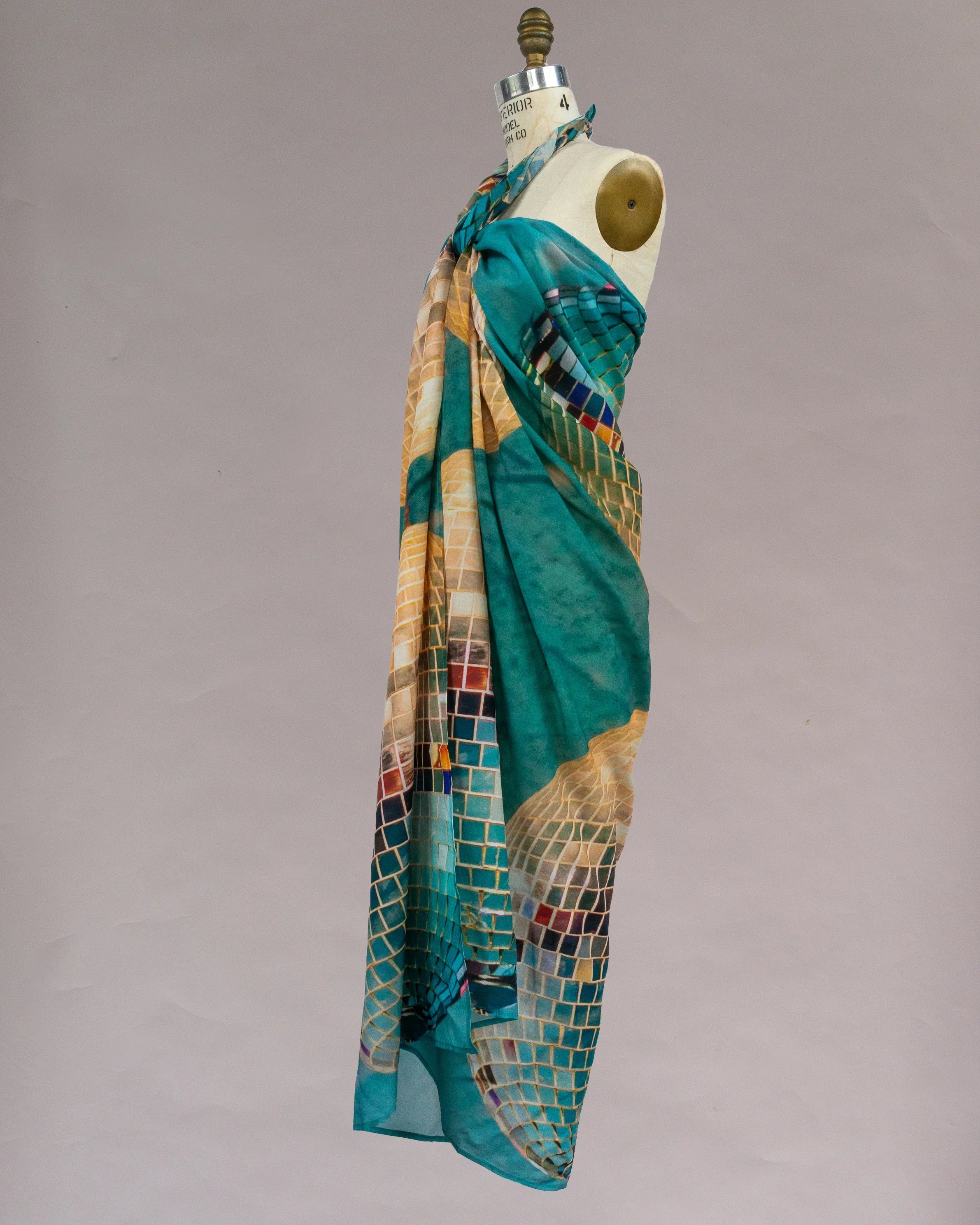 Turquoise pareo with mosaic tile print draped on dress form, modern Hawaiian style