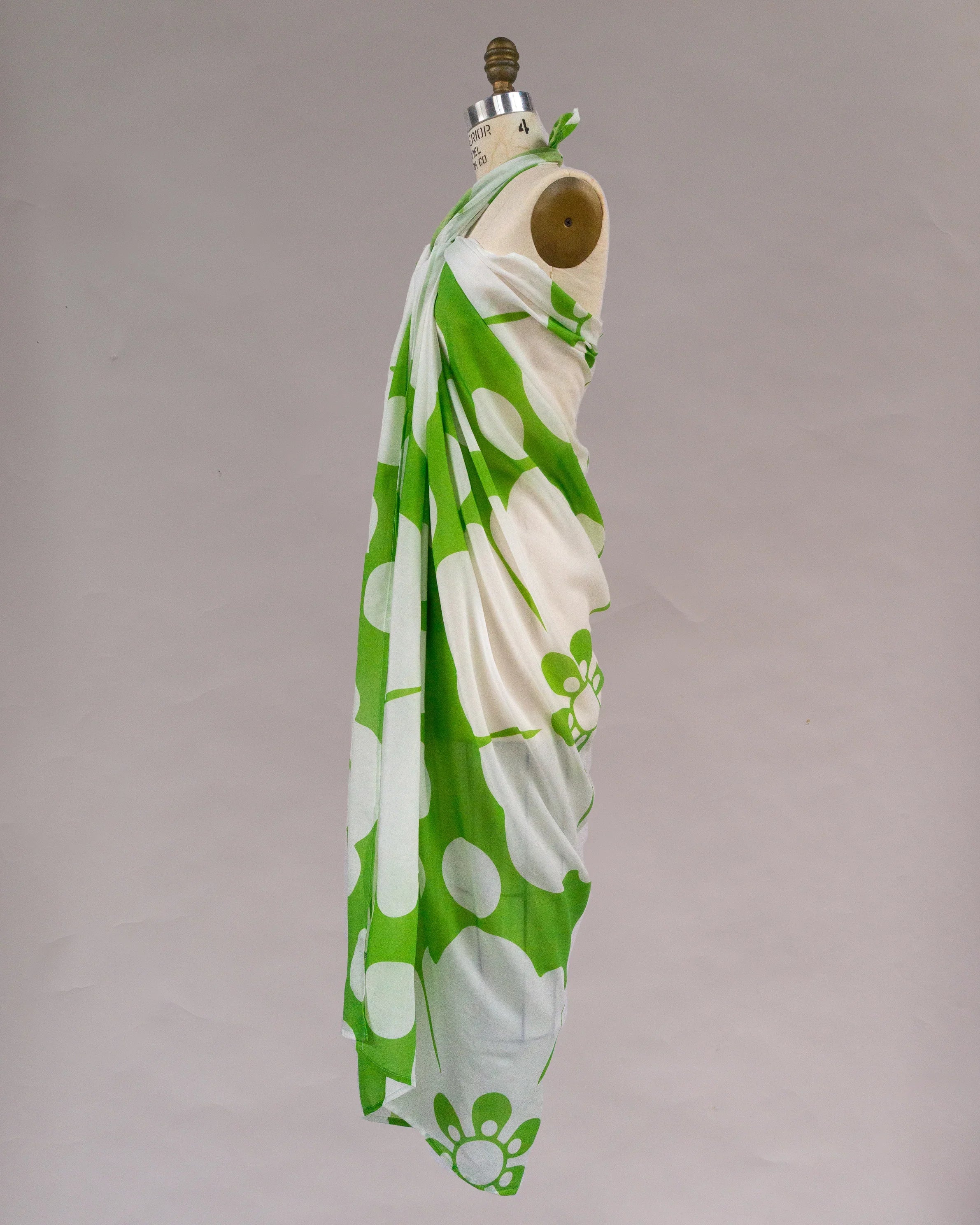 Green and white floral pareo sarong draped on mannequin, modern Hawaiian print