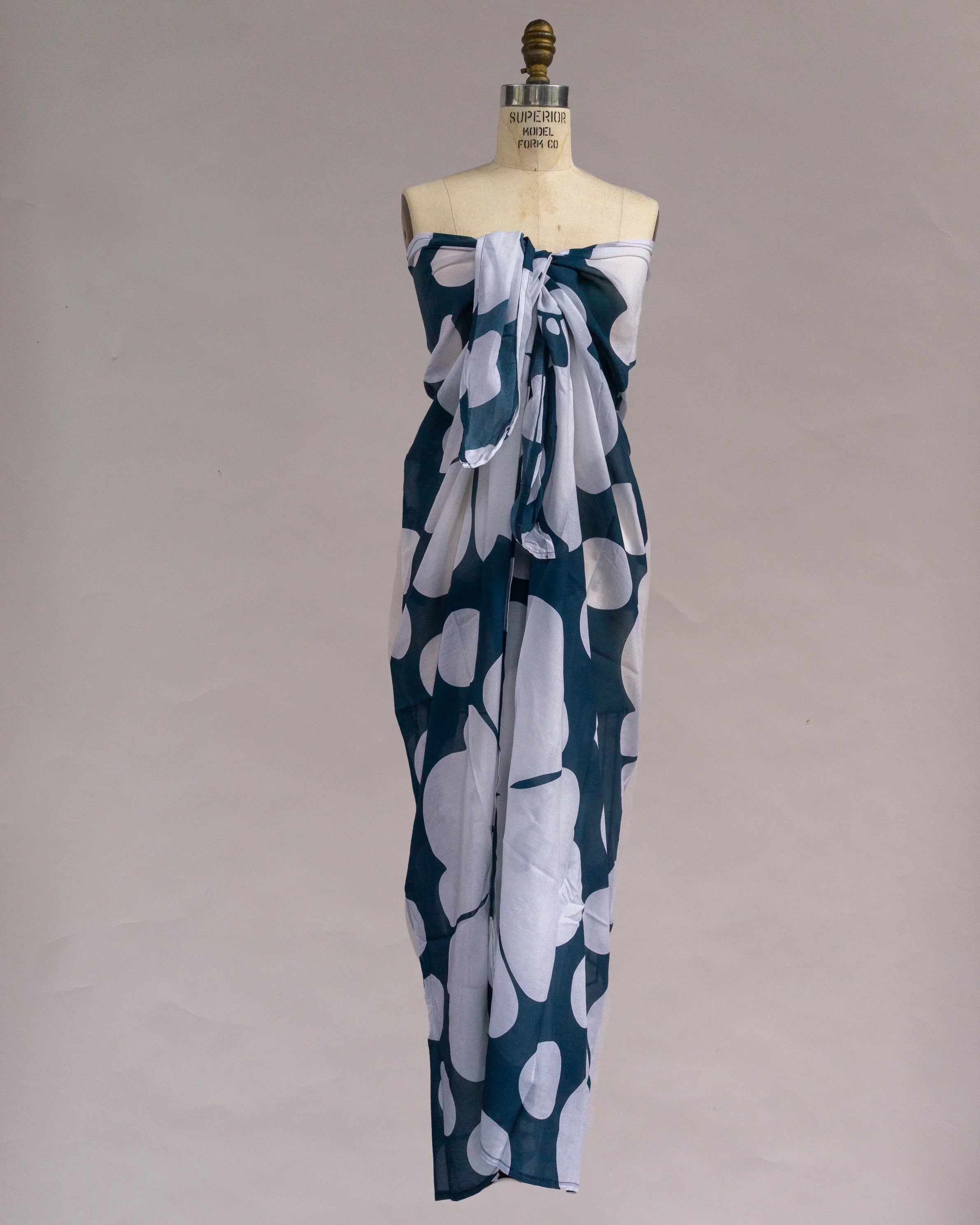 Navy blue and white pareo sarong with bold Hawaiian print, displayed on dress form