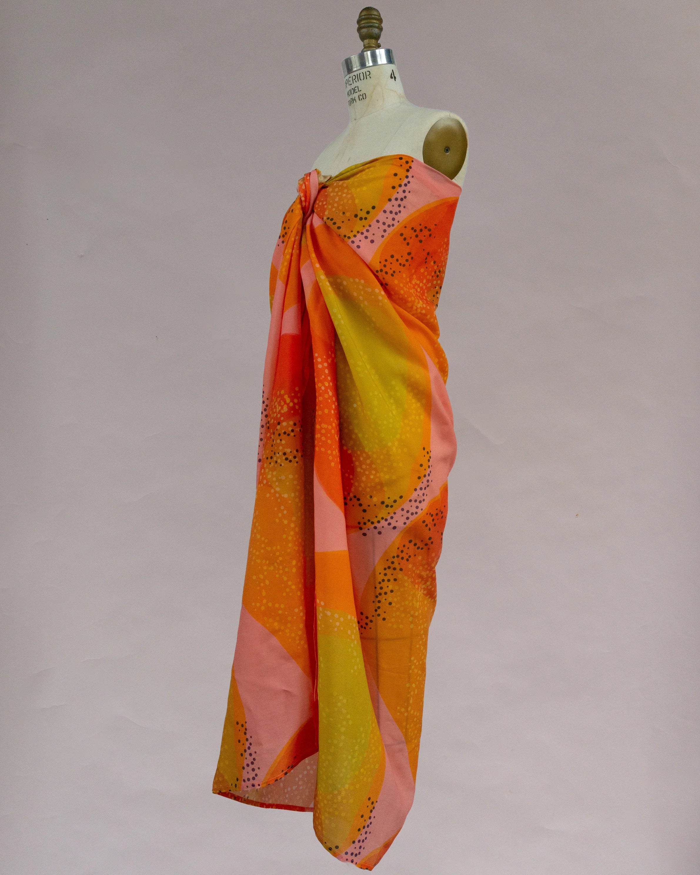 Orange and yellow Hawaiian pareo with abstract print displayed on dress form