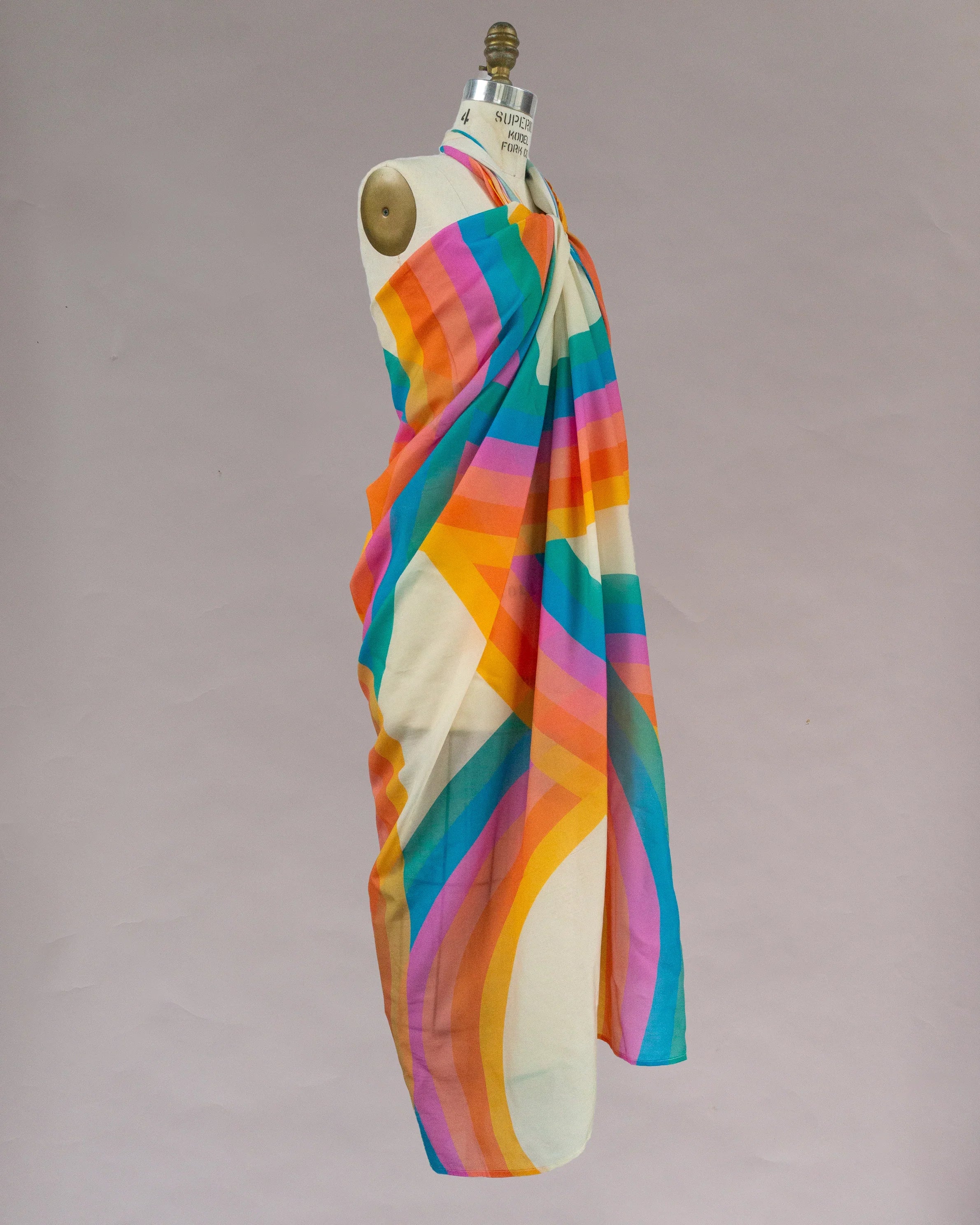 Colorful pareo sarong with rainbow geometric stripes draped on mannequin