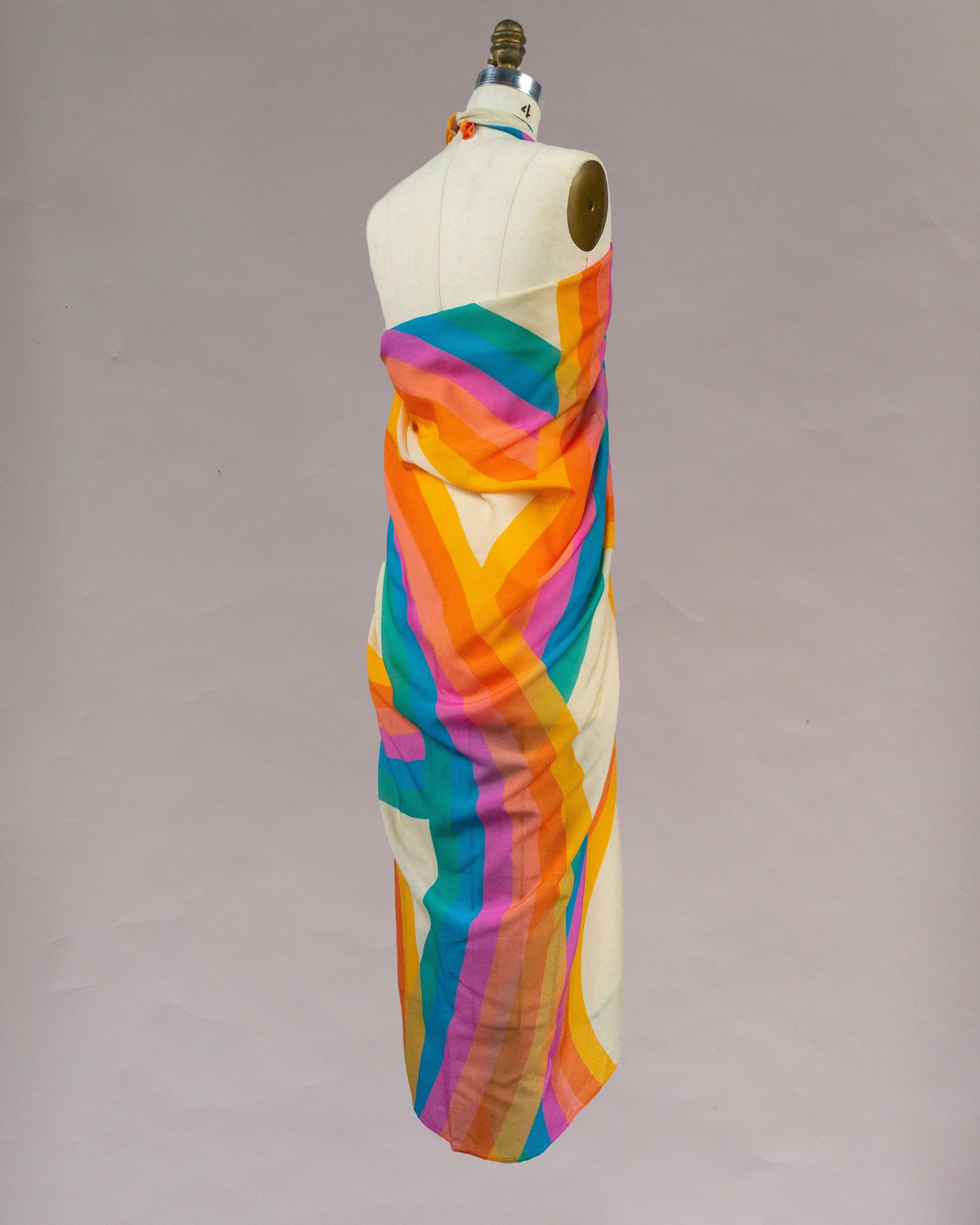 Sheer rainbow pareo wrap with bold colorful stripes on mannequin, Hawaiian-inspired style