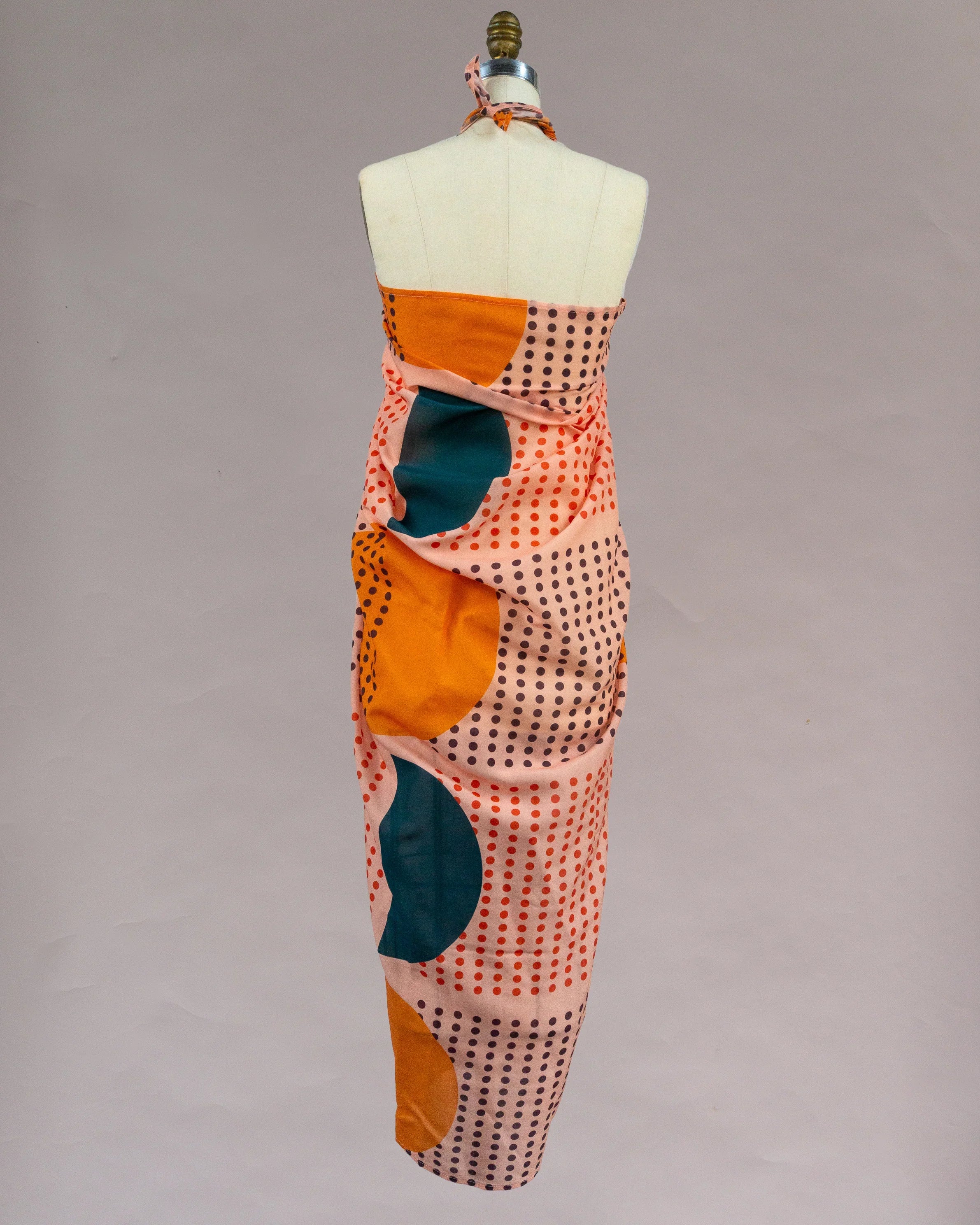 Back view of a mannequin wearing a colorful pareo with modern Hawaiian print and polka dots.