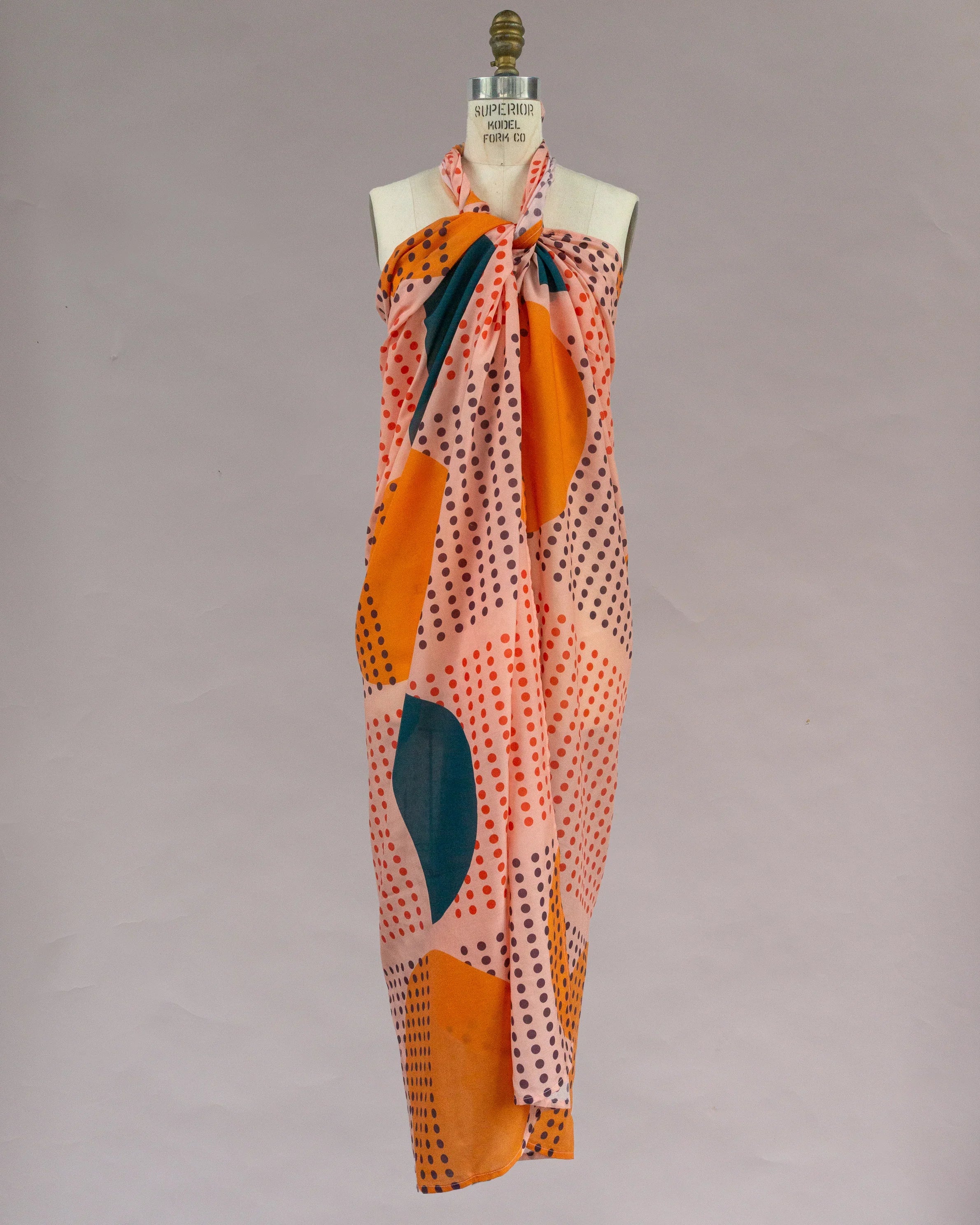 Colorful pareo wrap with abstract Hawaiian print in orange, teal, and pink on mannequin