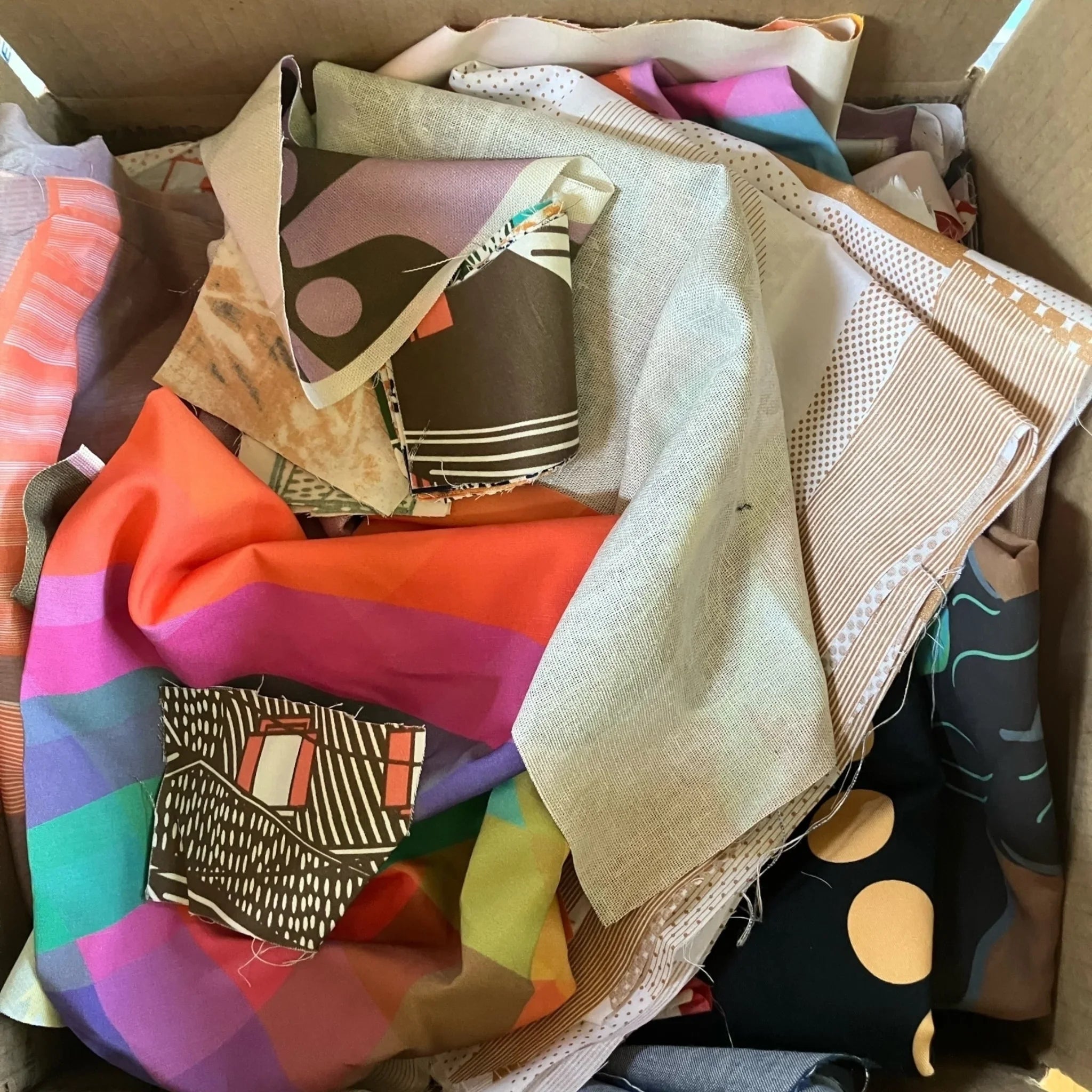 Box of colorful Hawaiian fabric scraps with bold modern prints and patterns