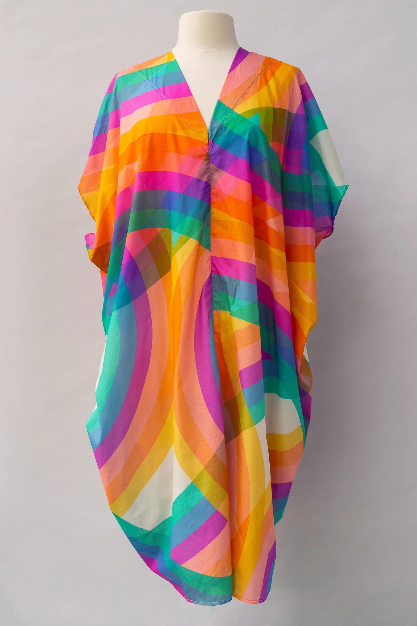 Colorful modern muumuu dress with bold, geometric Hawaiian print on mannequin
